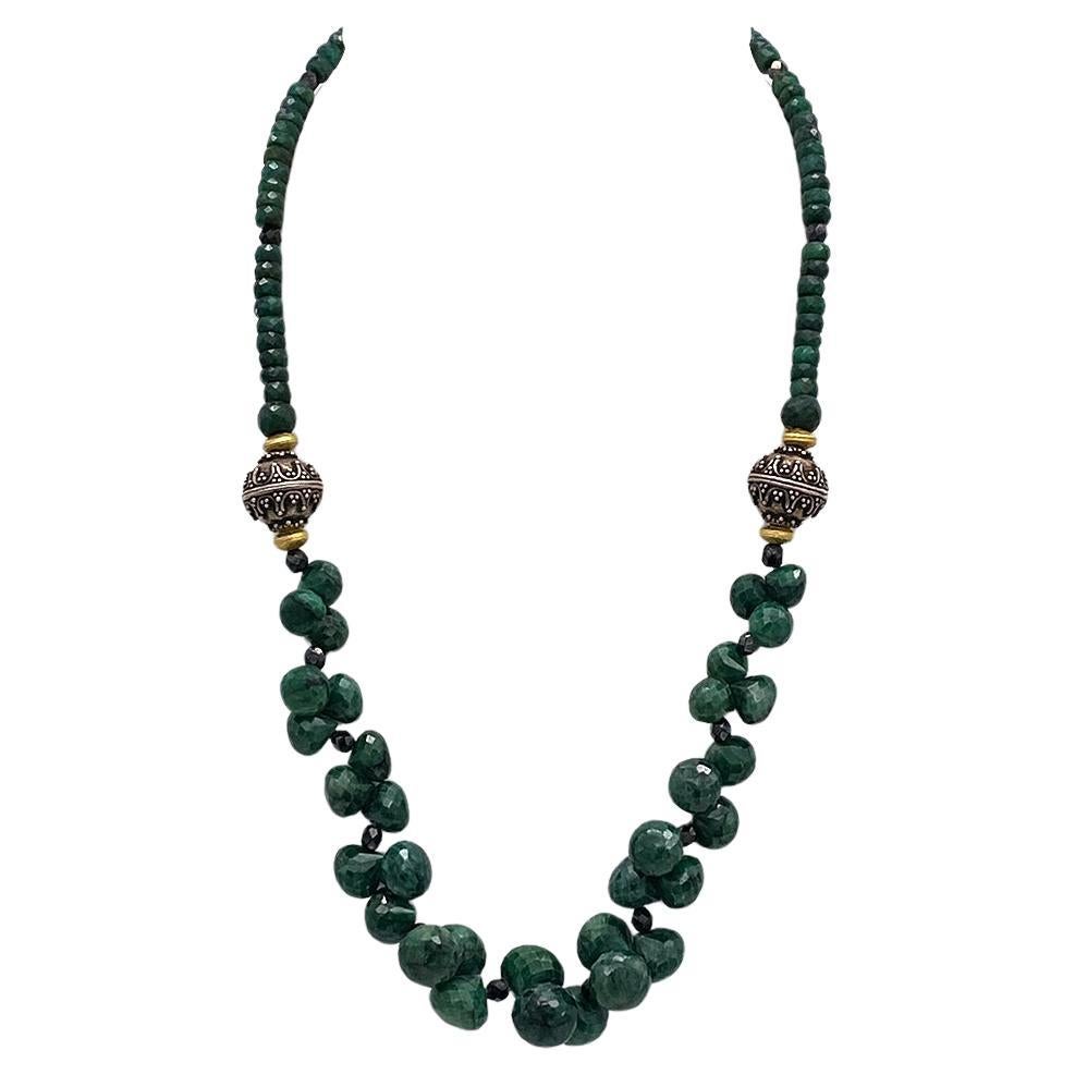 This is an emerald necklace with a diamond clasp. We created it with up to 11 mm faceted candy kiss cut emeralds and 5 mm rondel emeralds. It's decorated with sterling silver oxidized Bali beads and comes with a diamond encrusted clasp.

Our vintage