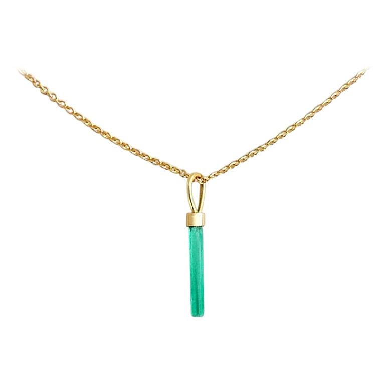 This delicate 18-karat gold necklace features a natural needle-shaped Colombian emerald pendant on a 16-inch solid gold chain.  The emerald is set with a cap and ring crafted in 18-karat gold which is can be removed from the chain to be added to
