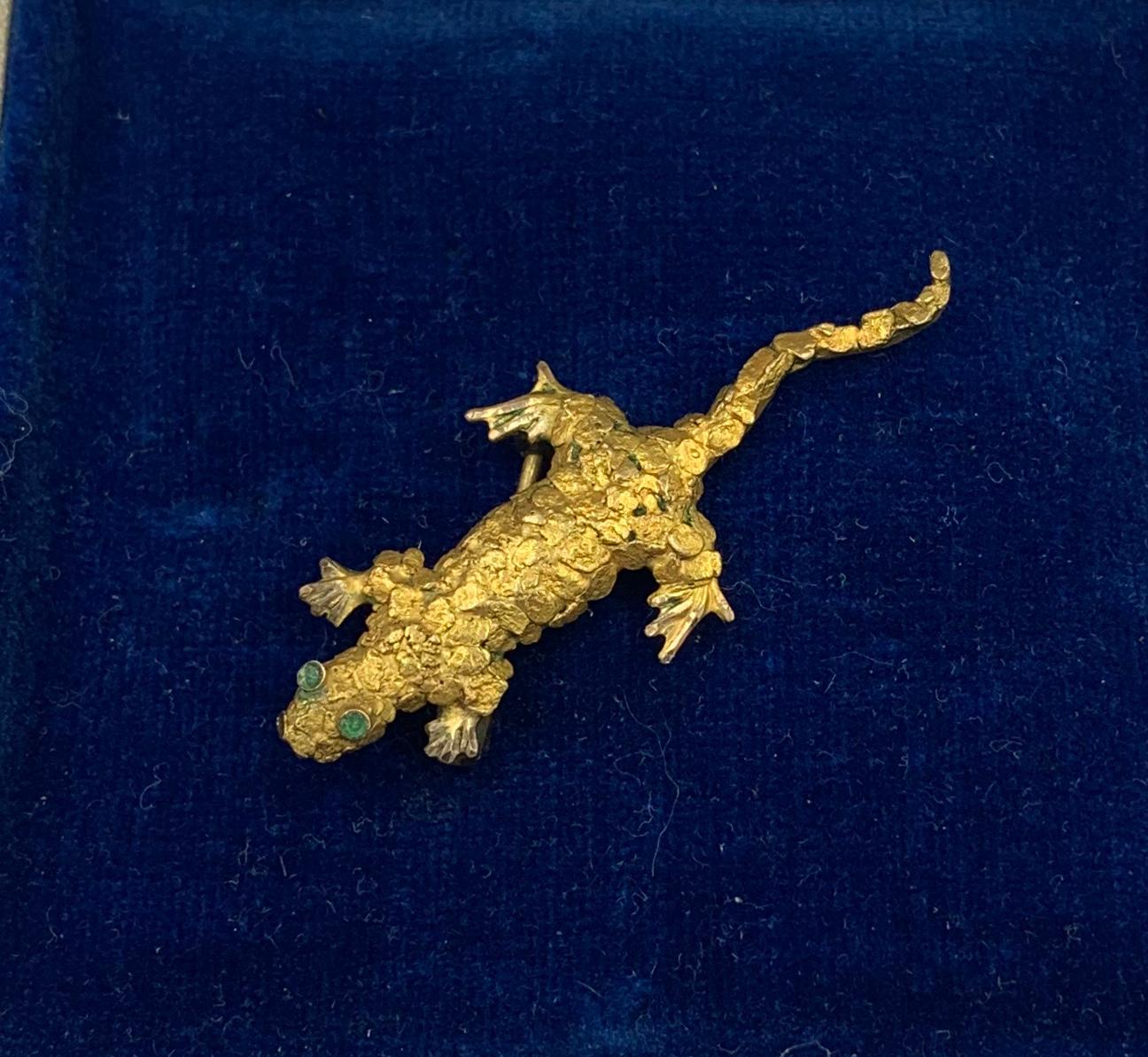 Une adorable broche lézard, gecko rétro moderne du milieu du siècle avec des yeux en émeraude en or 10 carats.  Le merveilleux lézard est fait de pépites d'or jaune 10 carats.  Le lézard a des yeux d'émeraude étincelants.  Le lézard a un superbe