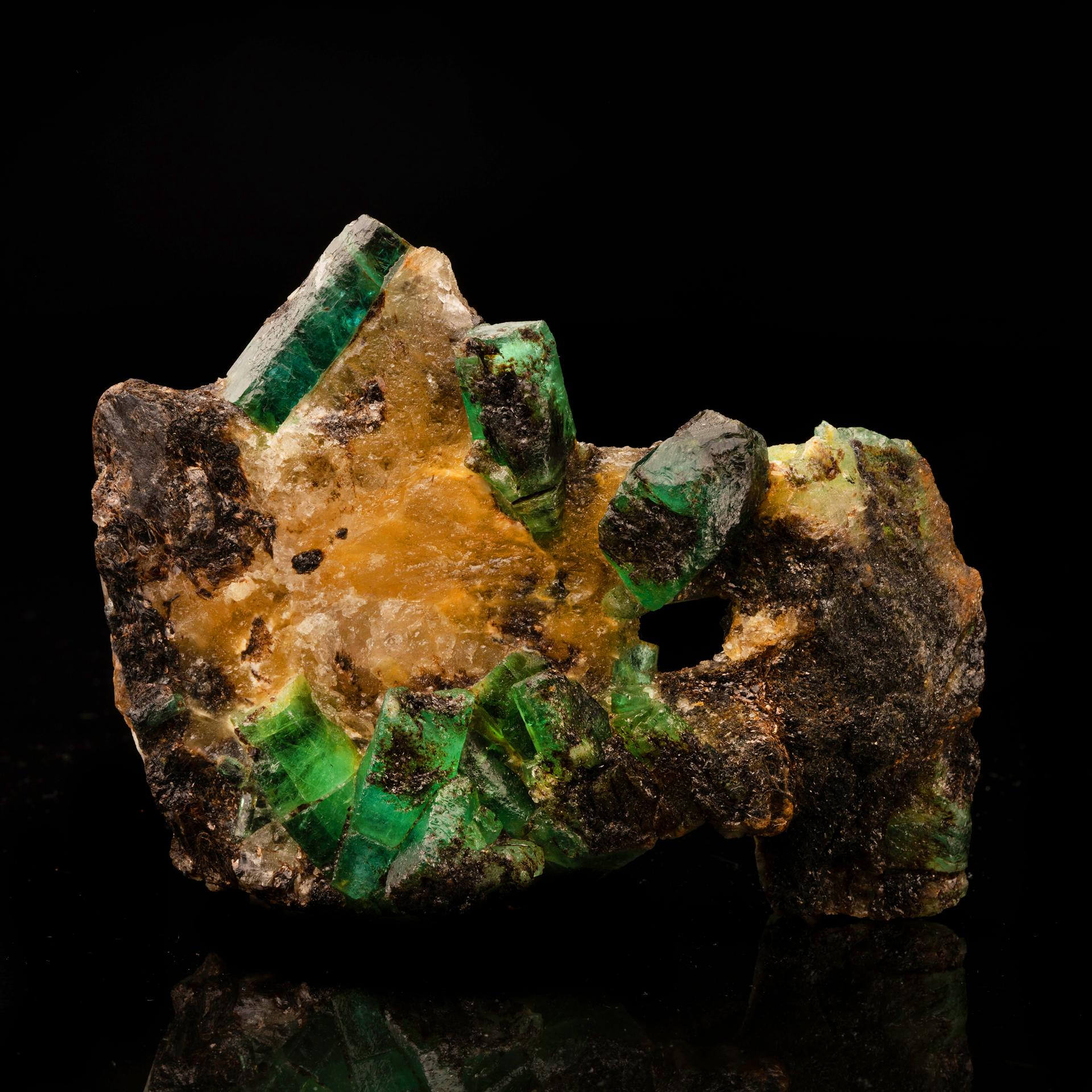 This luxurious offering serves up vibrant tones of verdant emerald on a canary yellow calcite and shimmering, earthy biotite matrix for a gemmy study in contrast. A unique and arresting acquisition sure to add color and style to your