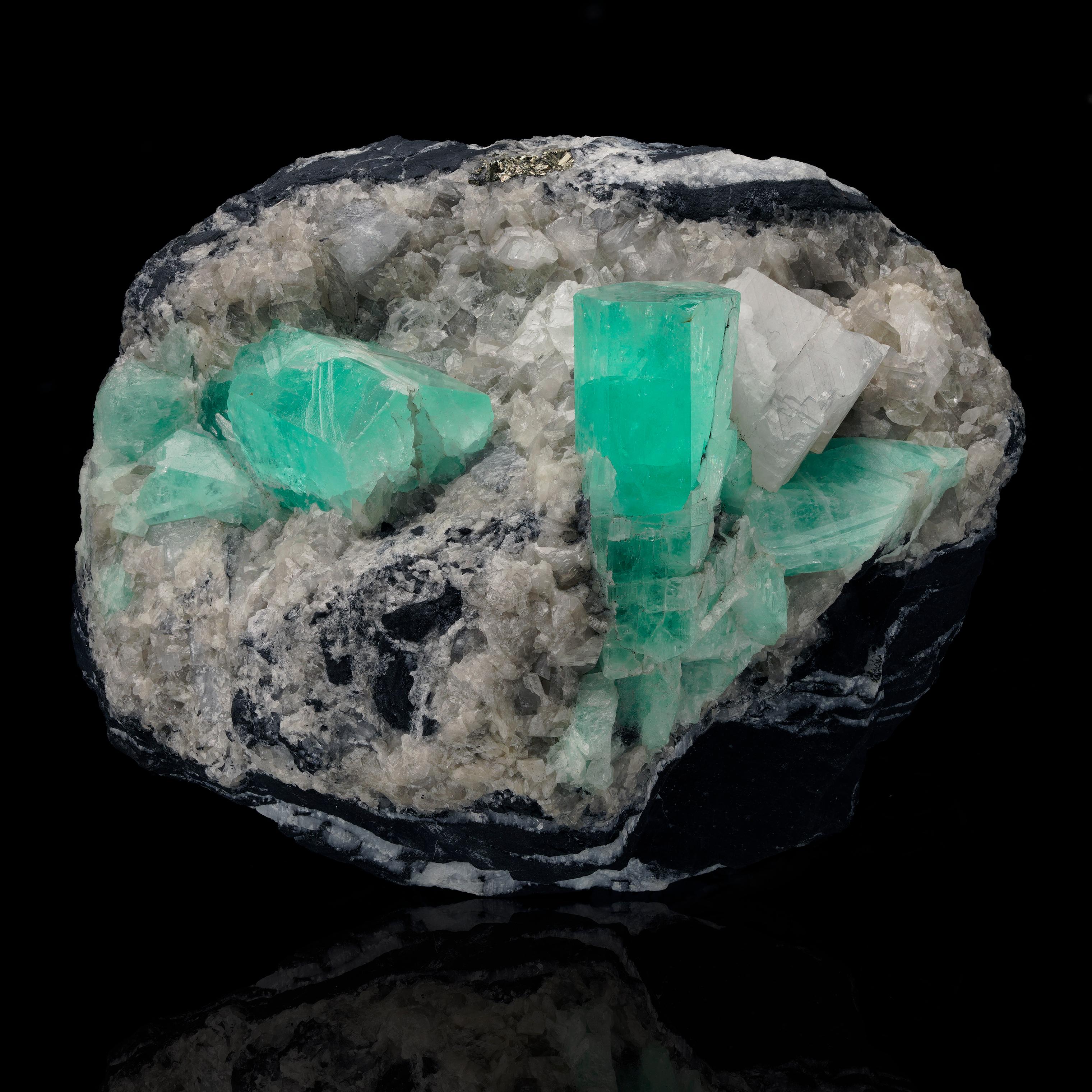 Ce spécimen combiné de 1,74 lb de qualité muséale provenant des mines d'émeraude de Muzo en Colombie présente deux grands cristaux d'émeraude magnifiquement formés - chacun mesurant environ 1,5 pouce de long et le plus grand des deux cristaux