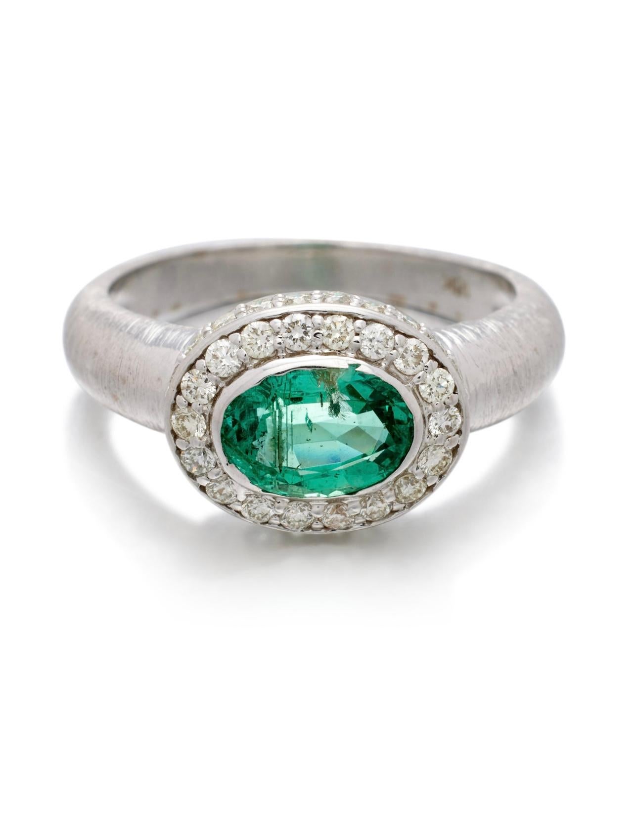 Centering an oval shape emerald, accented by 18round diamonds. 

Emerald weighs approximately 1.10 carats 
Diamonds weighing a total of approximately 0.40 carat. 
Metal Type : 18K white gold 
Gold weight : 5.30 grams 
Ring size : 7 1/2 
