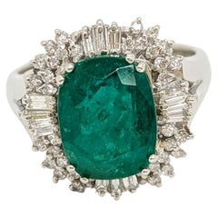 Emerald Oval and White Diamond Cluster Ring in Platinum