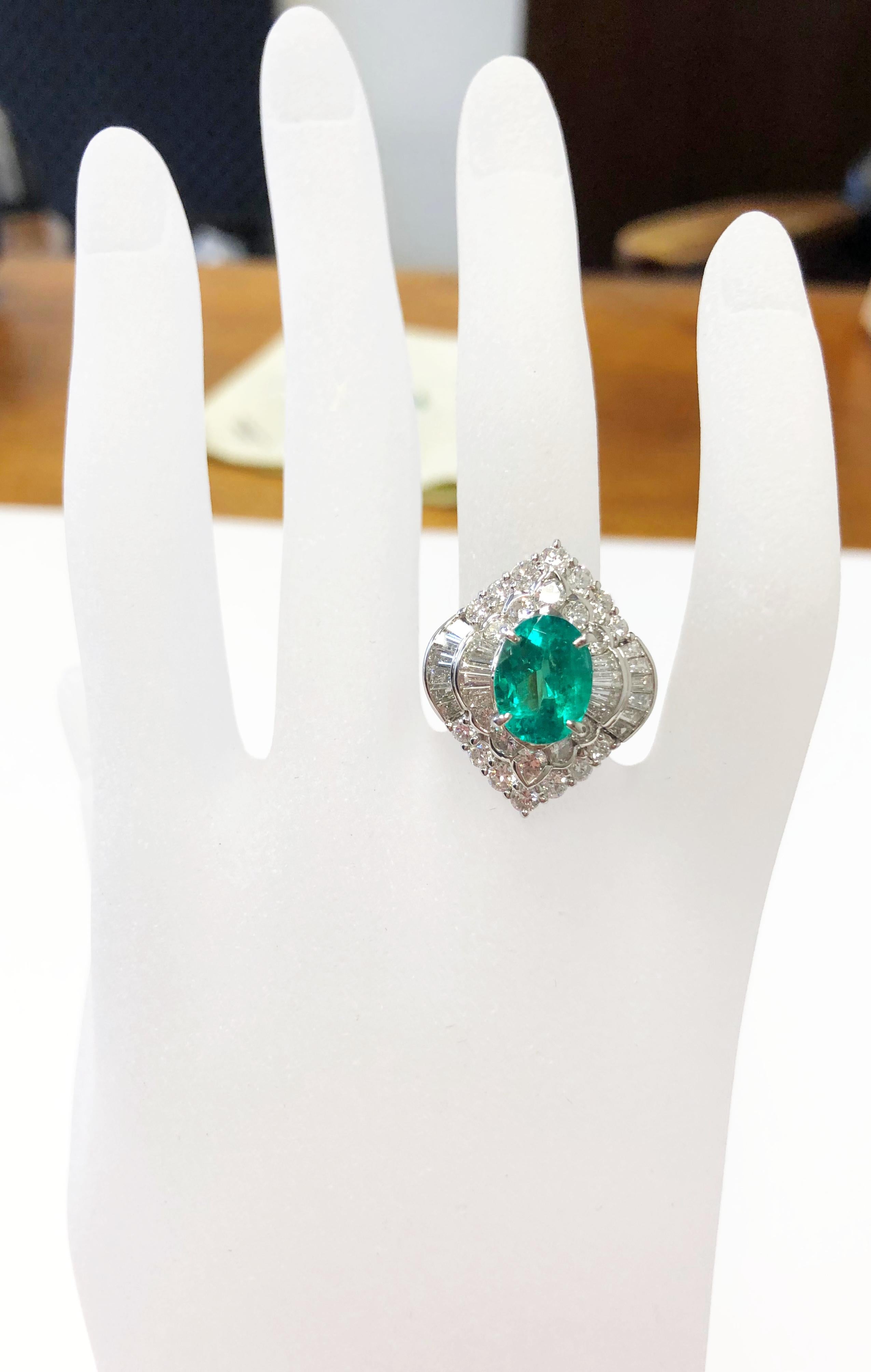 Alluring oval emerald weighing 3 carats with bright white diamond rounds and baguettes weighing 2.34 carats.  Handcrafted platinum mounting in size 7.  The emerald is bright and deep green, ideal shape and color.  Perfect for someone who loves