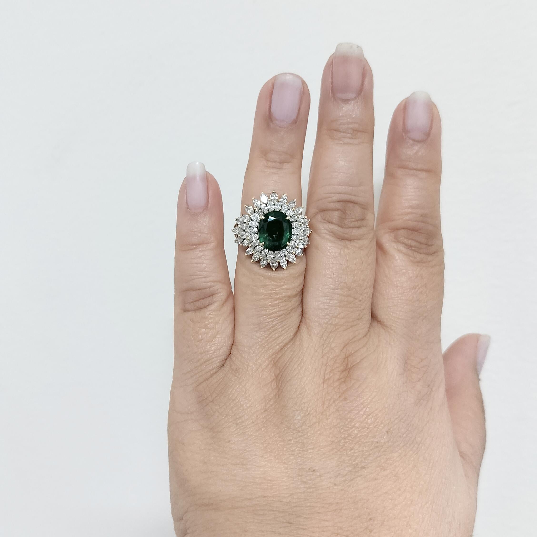 Beautiful big emerald oval (approximately 4 ct) with good quality white diamond marquise shapes.  Handmade in 18k yellow gold.  Ring size 7.