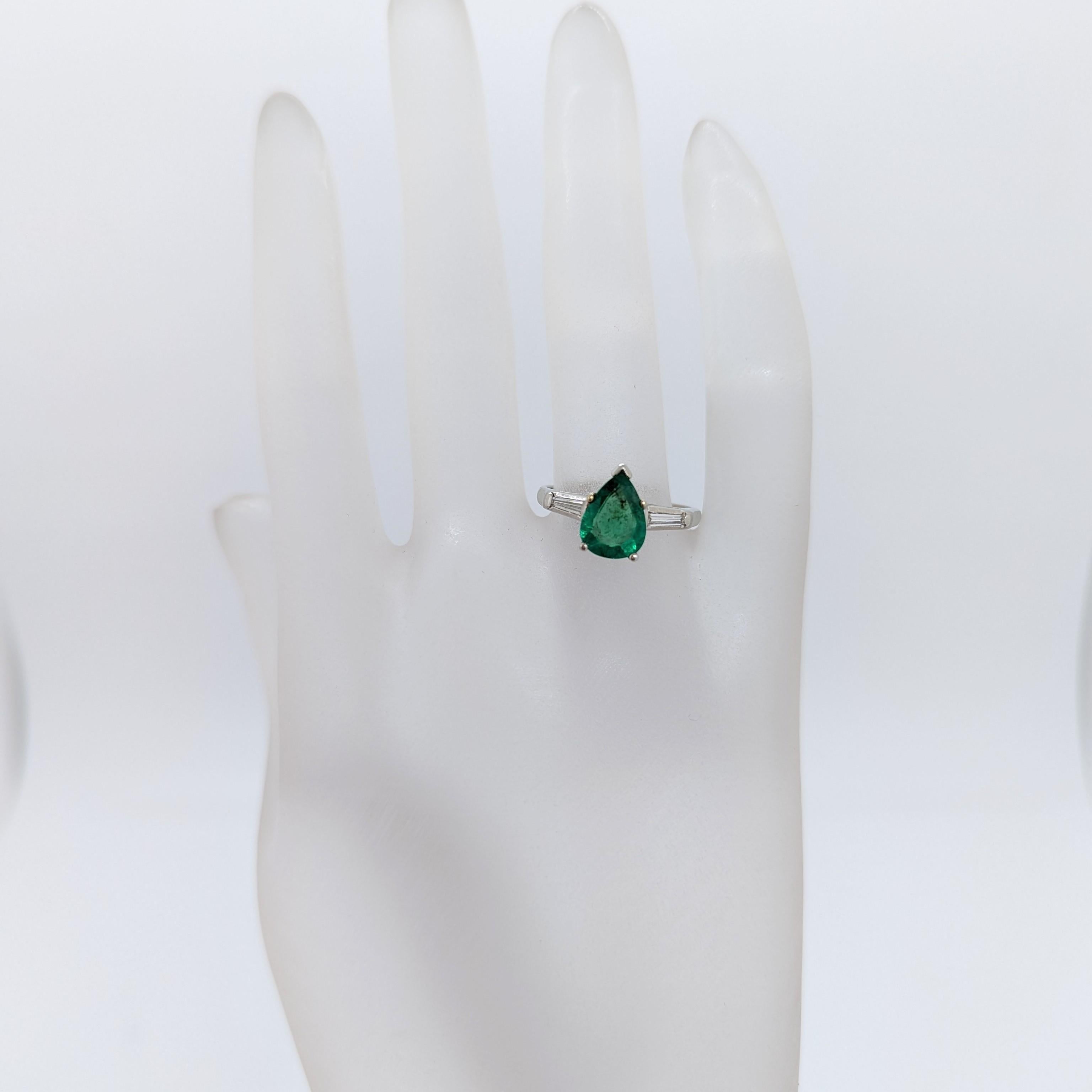 Beautiful 1.29 ct. emerald pear shape with 0.10 ct. white diamond baguettes.  Handmade in platinum.  Ring size 6.5.