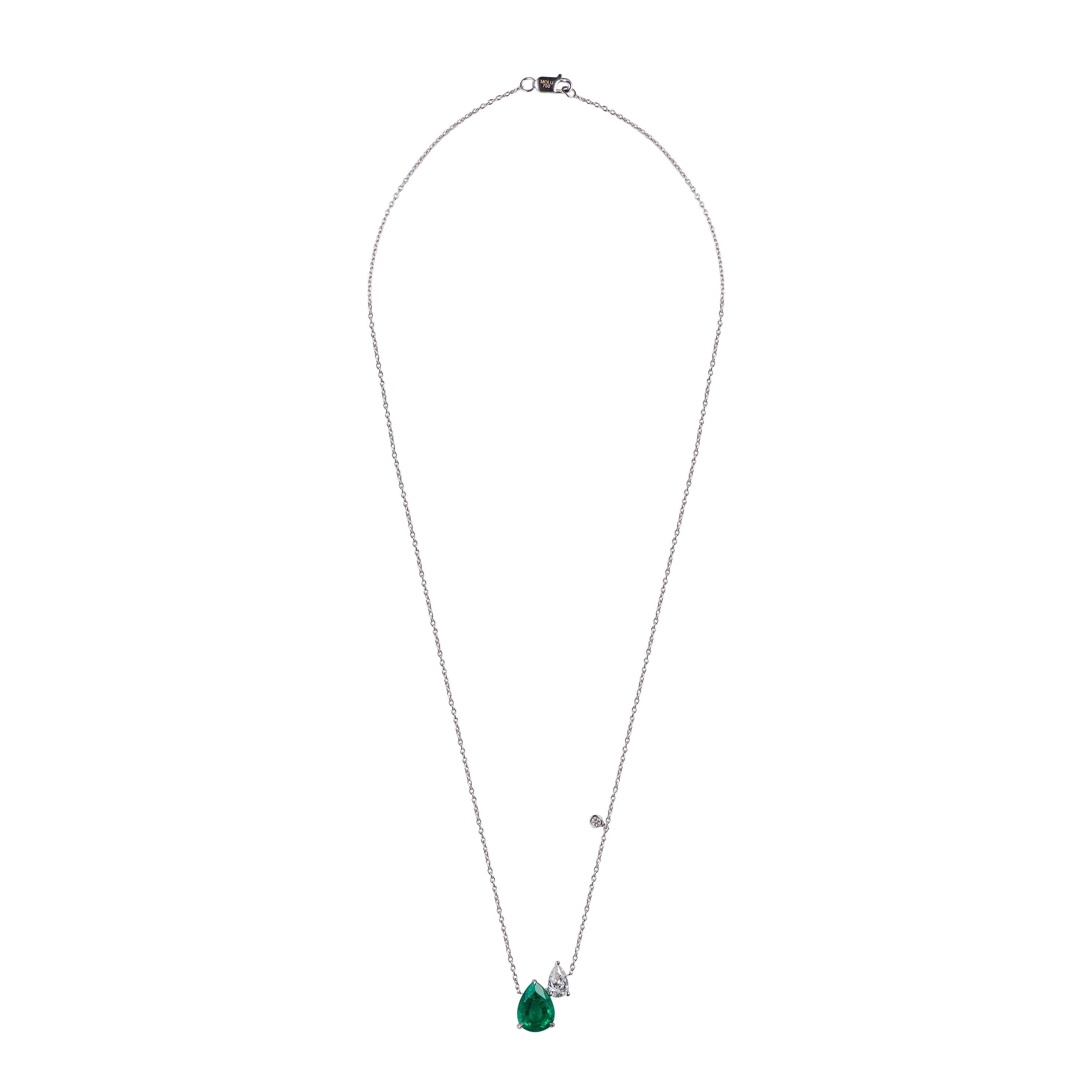 This simple and elegant necklace features a pear shaped faceted emerald as the center stone and an assymetrically set pear shaped dimaond accents the emerald. The little round brilliant diamond hanging from the chain adds a little extra brilliance