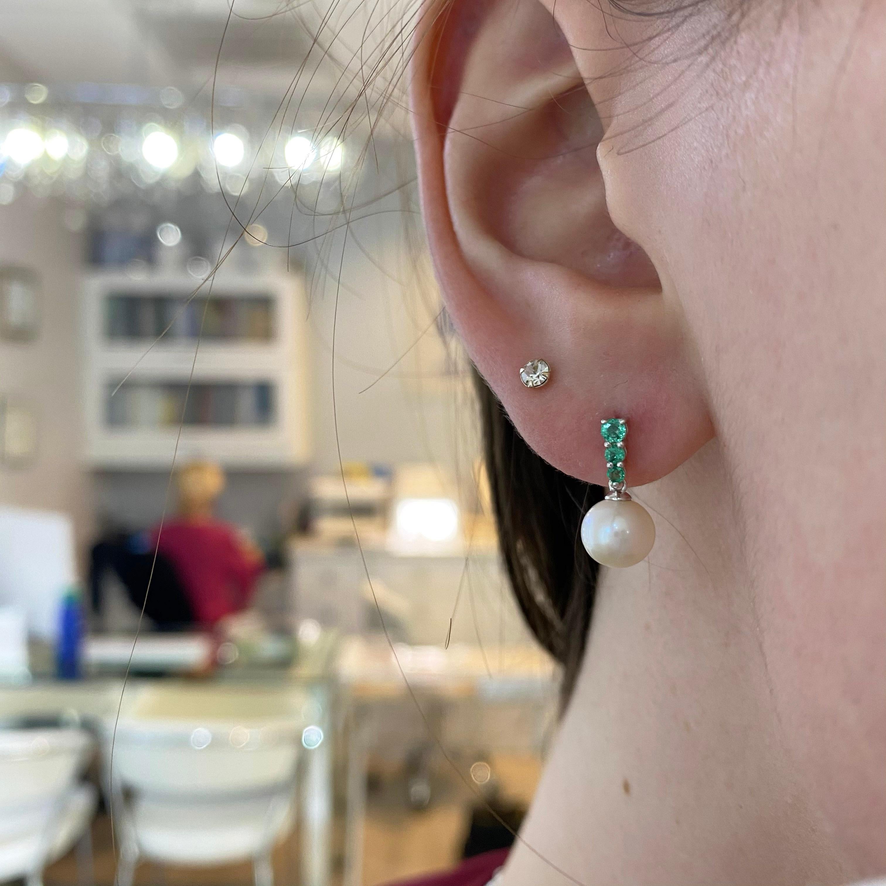 Bright green emeralds and gorgeous white pearls-what a match! The details for these gorgeous earrings are listed below:
Metal Quality: 14 k White Gold 
Earring Type: Drop 
Gemstone: Emerald 
Gemstone number: 3
Gemstone Weight: .25 carats
Gemstone
