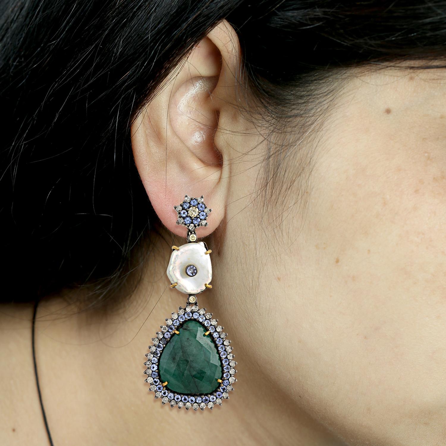 Gorgeous 3 tier sliced emerald and pearl earring with flower motif on top with diamonds and tanzanite. This earring has push and post to wear.

18kt: 2.316gms
Diamond: 2.10ct
Silver:13.54gms
Emerald:18.60ct
Tanzanite: 2.62ct
Pearl: 14.35ct