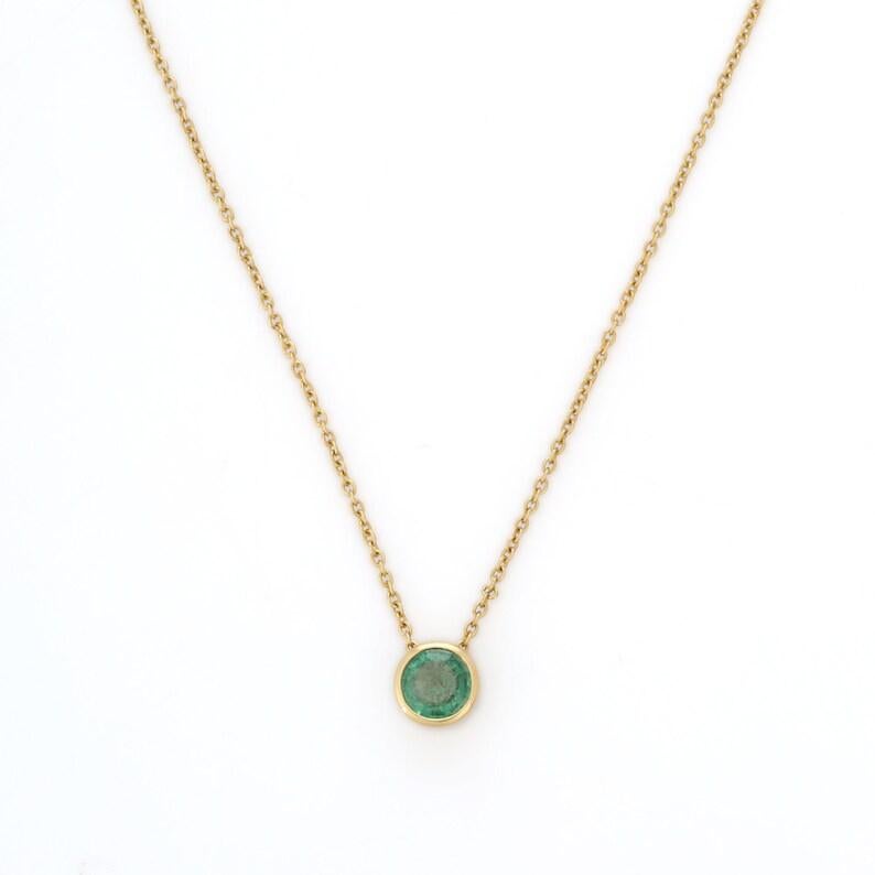 Elegant Emerald Chain Necklace in 18K Gold studded with round cut emerald. This stunning piece of jewelry instantly elevates a casual look or dressy outfit. 
Emerald enhances the intellectual capacity. 
Designed with round cut emerald studded in