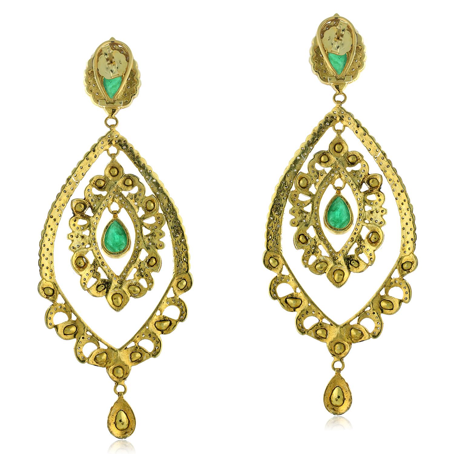 These earrings are typically made of gold or silver and feature emeralds and polki diamonds, which are uncut, natural diamonds that have a raw and rustic appearance. The earrings may also be accented with pave diamonds, which are small diamonds that