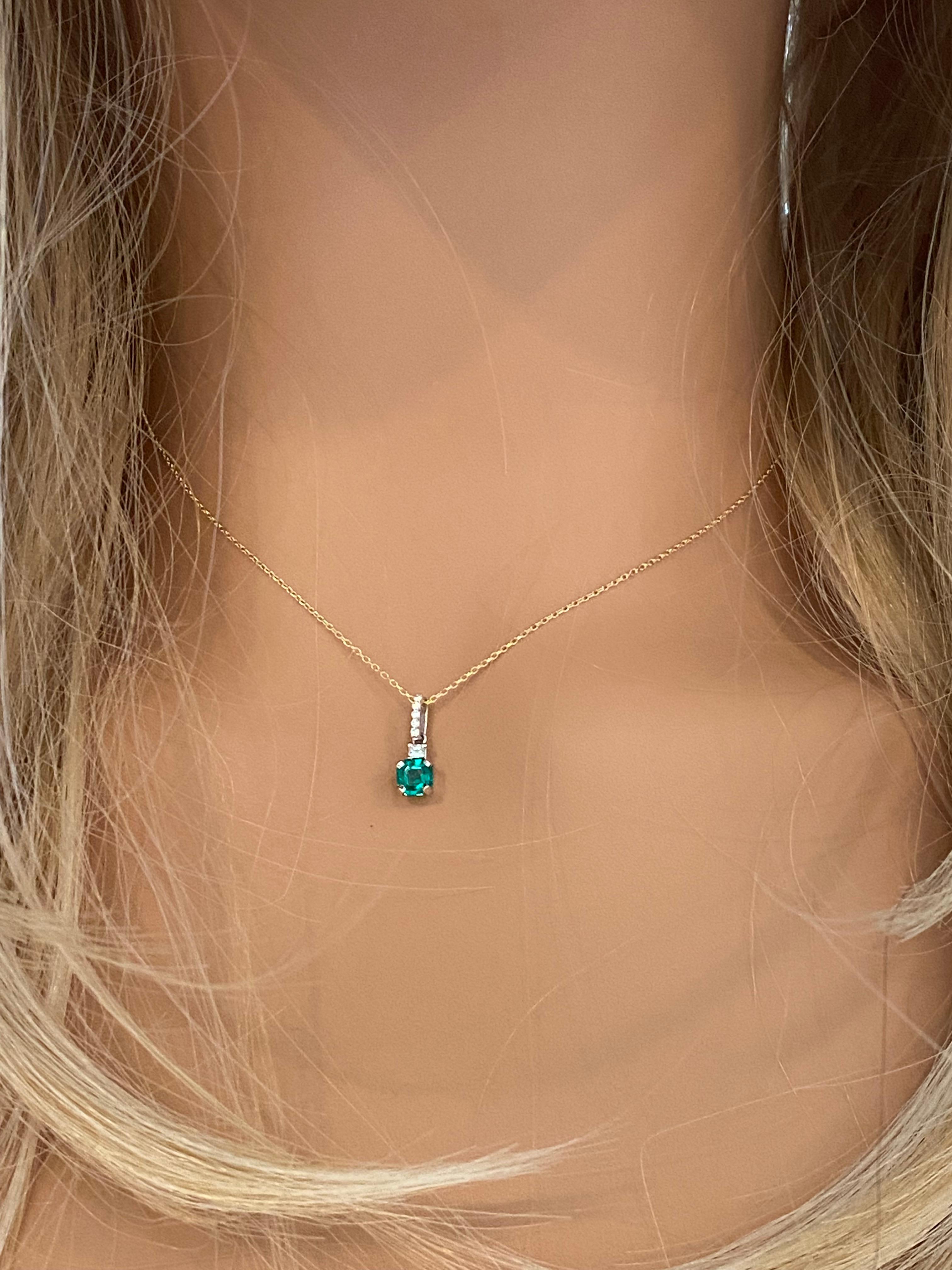 14 karats white and yellow gold necklace pendant with emerald-shaped emerald
Necklace measuring 16 inches long
Colombia emerald-cut emerald  weighing 0.60 carats
One princess cut diamond weighing 0.10 carats
Diamond bail weighing 0.09 carats
Emerald