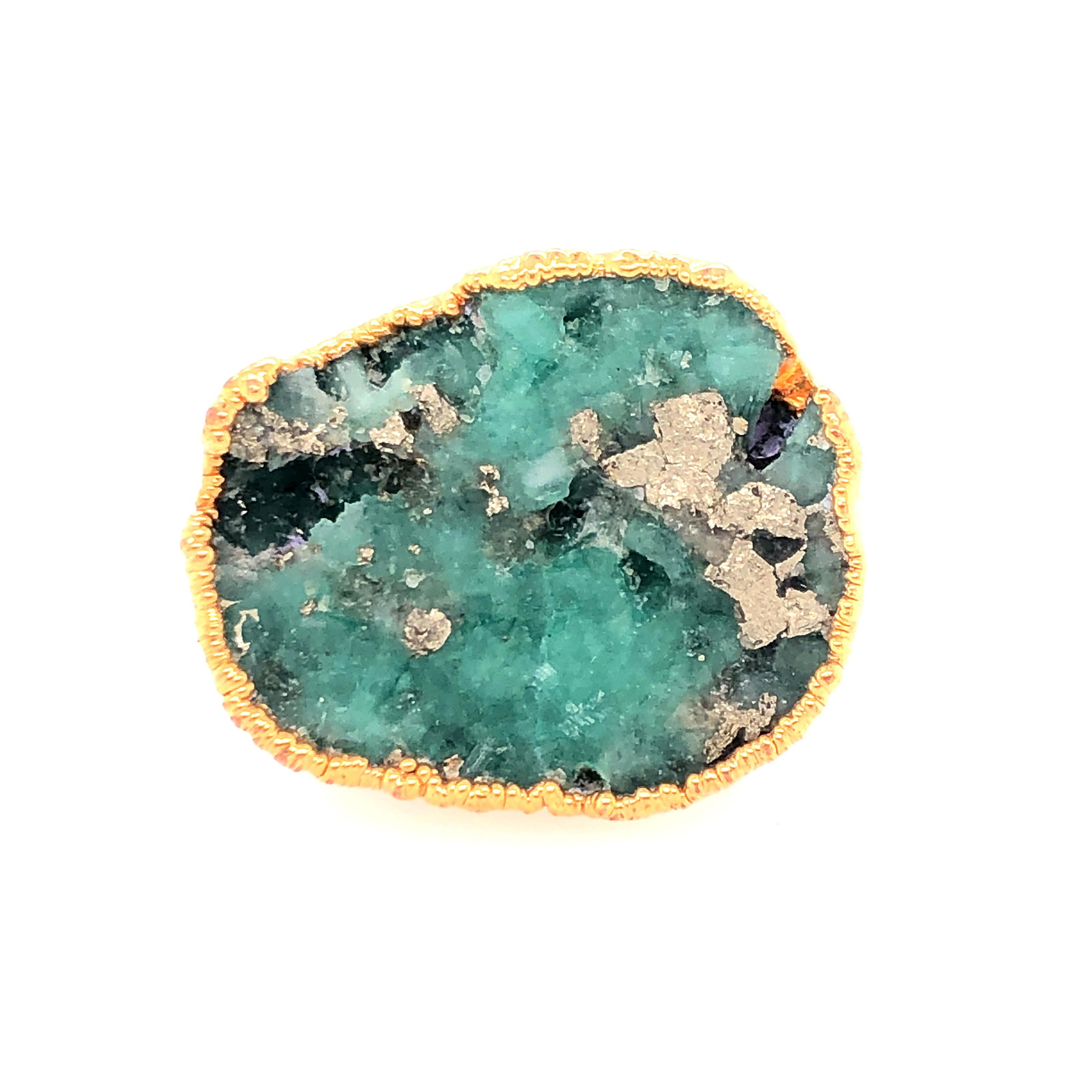 The natural formations of pyrite in this emerald ring make it just that much richer. The irregular forms of the emerald are embraced by the pyrite creating glimmering canyons. The emerald sits on its horn ring wrapped in gold accent. 

Size: 7