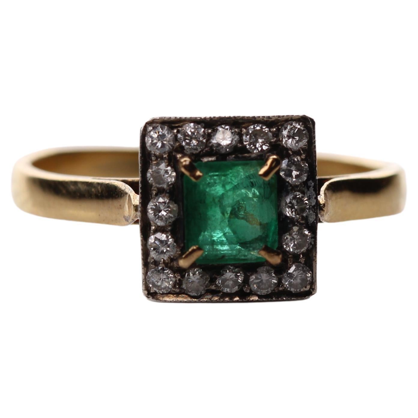 Beautiful Emerald Ring, surrounded by diamonds. The emerald is square shaped, transparent and has a great emerald green color. It weights ca. 0.45ct. The ring looks stunning on a hand. 
The 16 diamonds have a total weight of ca. 0.2ct and are alined