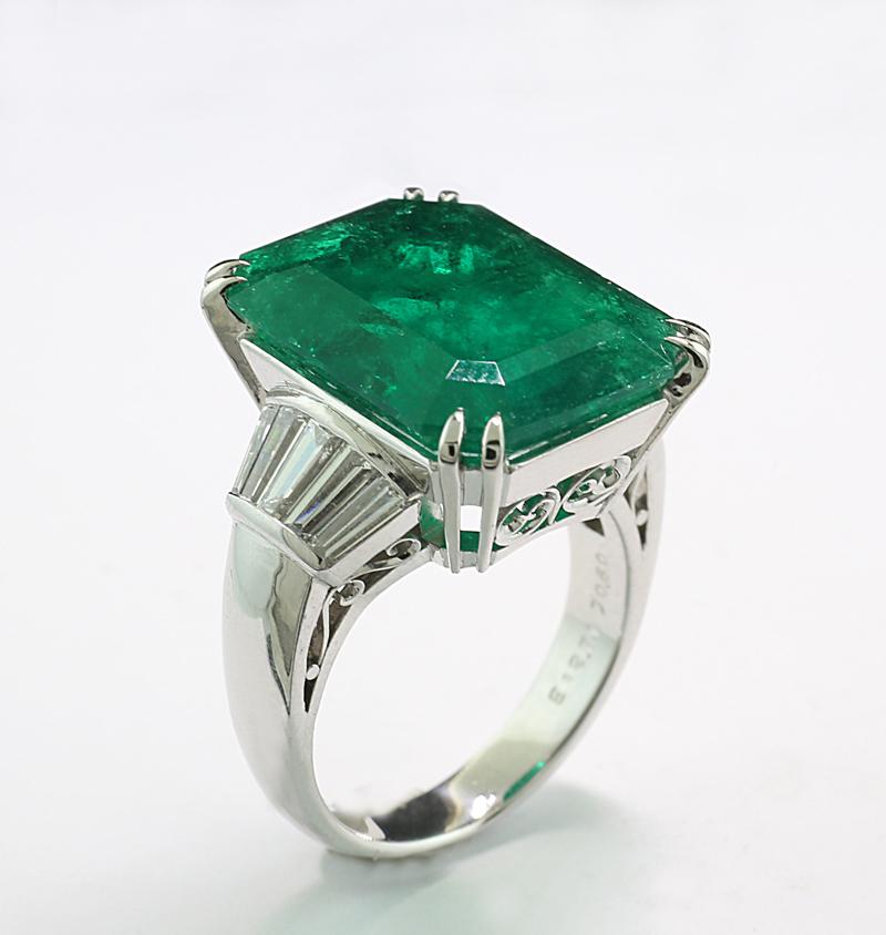 Ring mit einem kolumbianischen Smaragd von ca. 12,71 Karat, achteckig im Stufenschliff, mit der Darstellung eines lebhaften tiefen Grüns in transparenter Qualität, bemerkenswerter Brillanz und feiner Farbqualität.

Die Schultern des Rings sind mit