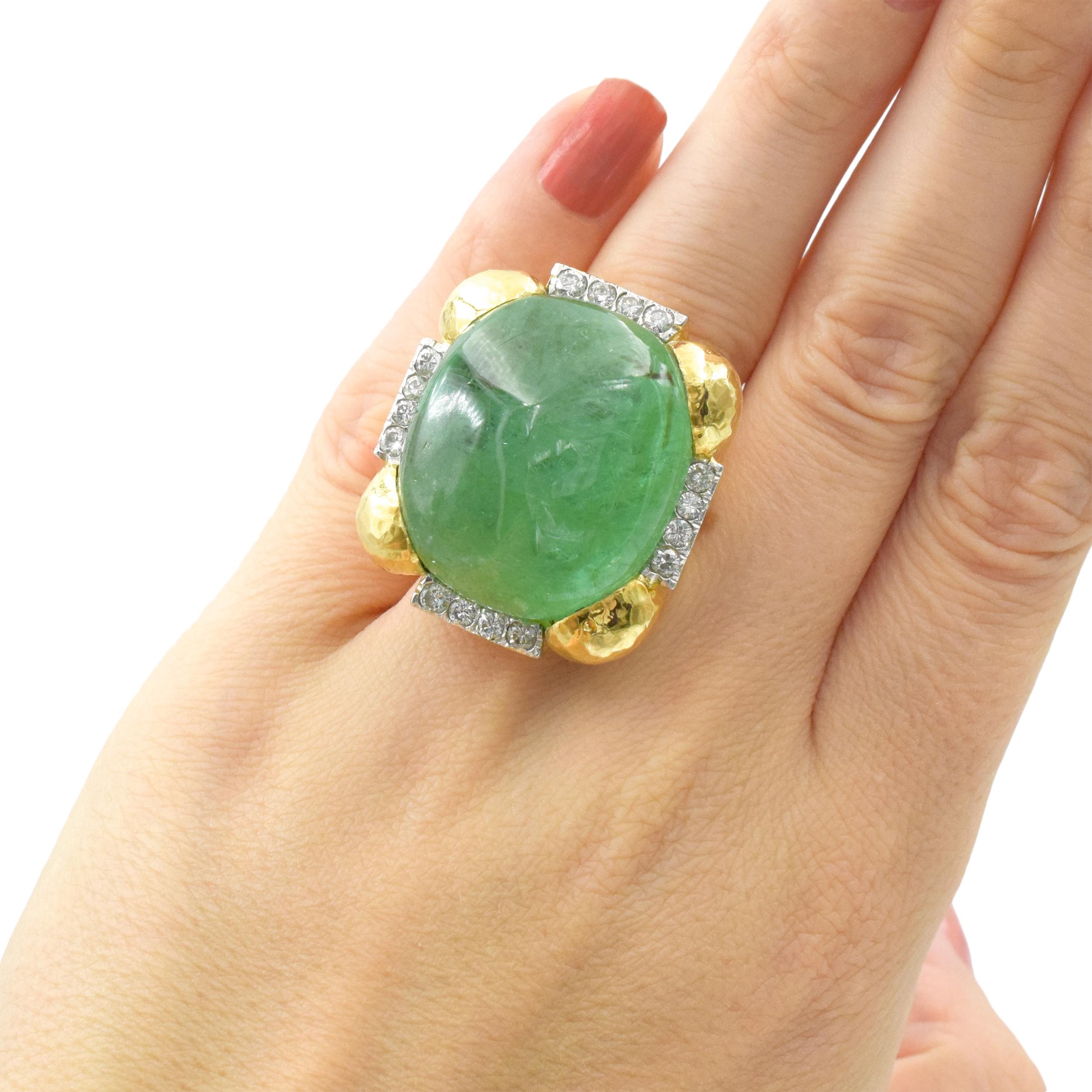 Emerald and diamond statement ring, created in 18k yellow gold. Center of thisring is set with
cabochon cut emerald (weight approx. 40 - 50ct), four sides of the ring flanked by rows of diamonds. Set 16 round brilliant cut diamonds with total weight