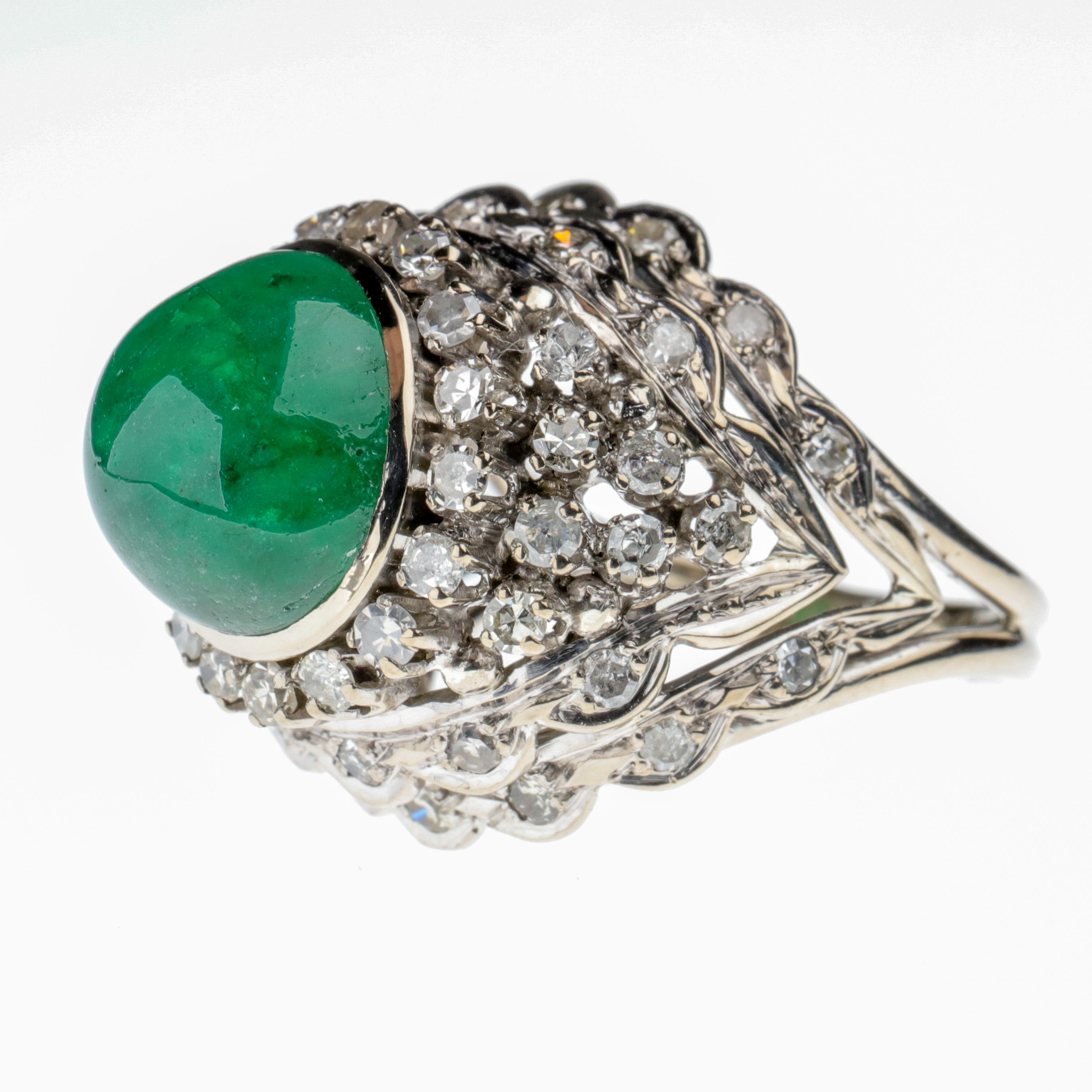 An over 5 ½ carat bright, soulful emerald cabochon measuring  11.23 mm x 10.79 mm is perched atop a hand-fabricated 14k white gold scaffolding in a kind of chevron configuration that supports 54 single-cut diamonds. This ring is bold, audacious,