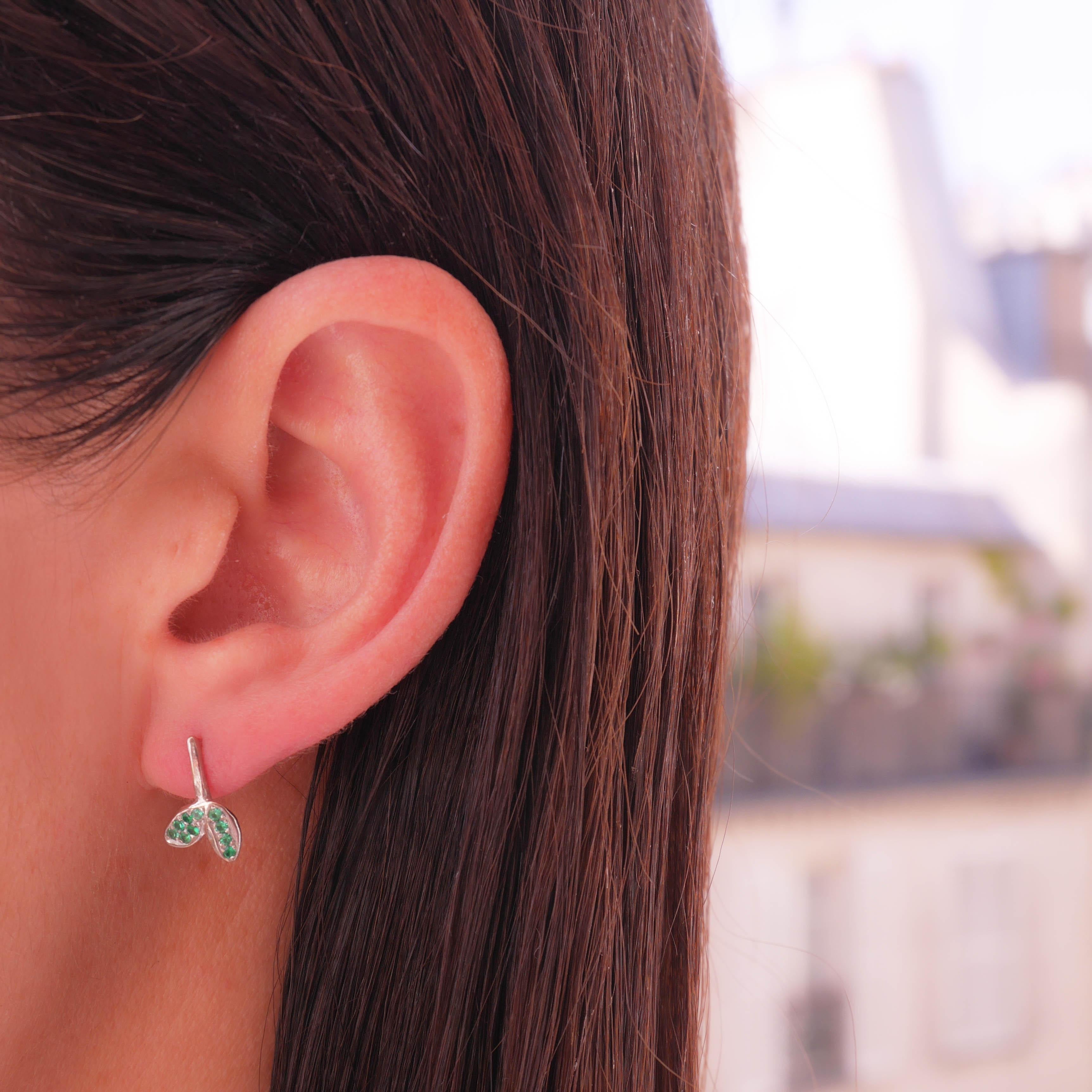 These Anais Rheiner handmade pair of 18 karat white gold earrings weigh approximately 2 grams. The earrings are set with emeralds and rubies and are asymmetrical with a butterfly fastening for pierced ears.
The craftsmanship is entirely hand made