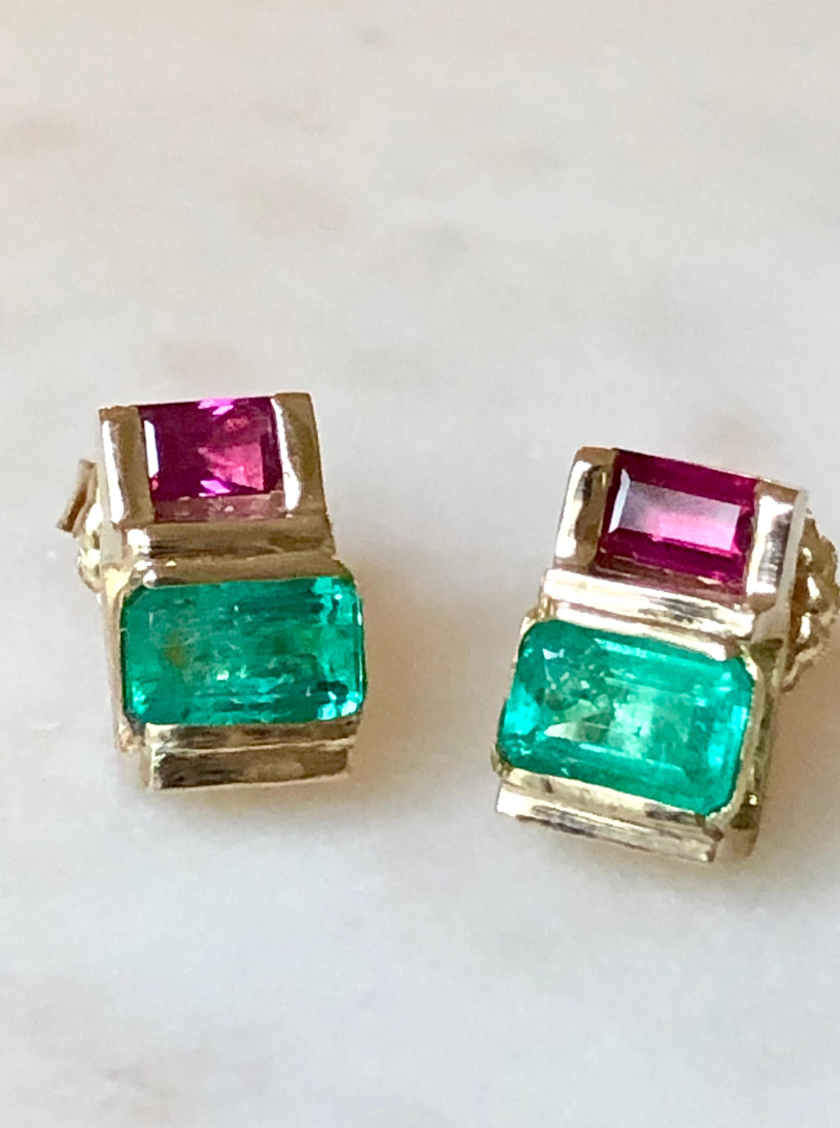 This elegant and contemporary pair of Emerald Ruby stud earrings features:
Primary Stone: Natural Colombian Emerald
Shape or Cut: Emerald Cut
Emerald Weight: Over 2.00 Carat (2 emeralds)
Average Color/Clarity Emerald: Fine Medium Green/VS
Accent