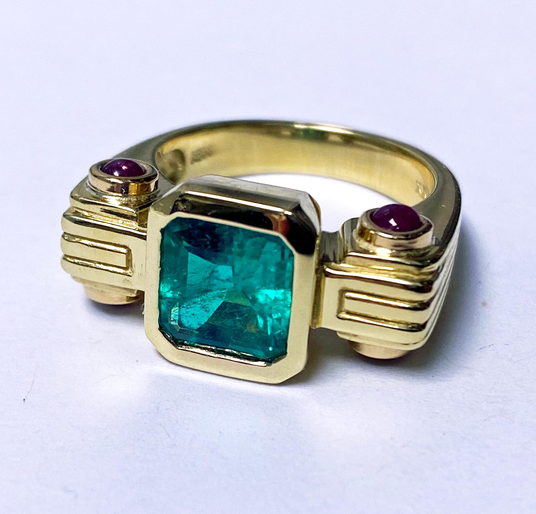 Emerald, Ruby and 18K Ring. Unisex custom made ribbed design, bezel set in the centre with an emerald cut natural  medium tone, strong Green Emerald, gauging 9.18 x 8.78 x 5.11mm, estimated weight calculated by formula 3.02 cts, SI1 clarity (type