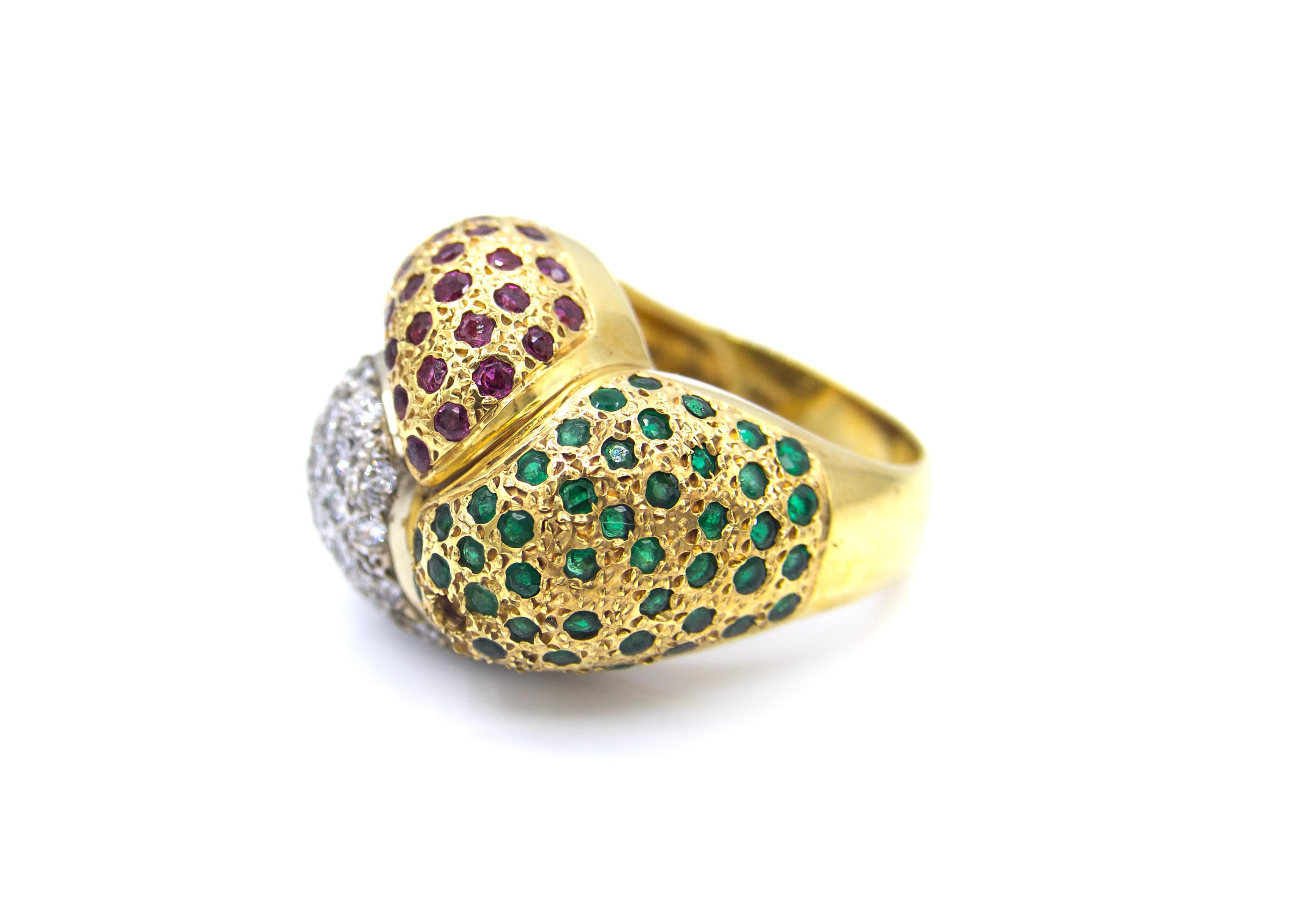 This 1990s emerald, ruby, and diamond cocktail ring is set in 18K yellow gold with white gold detailing for a two-toned look. The shape creates a twisted knot effect, with each part showing the different pave-set stones. 

16.7 grams

Size 6.5 
 