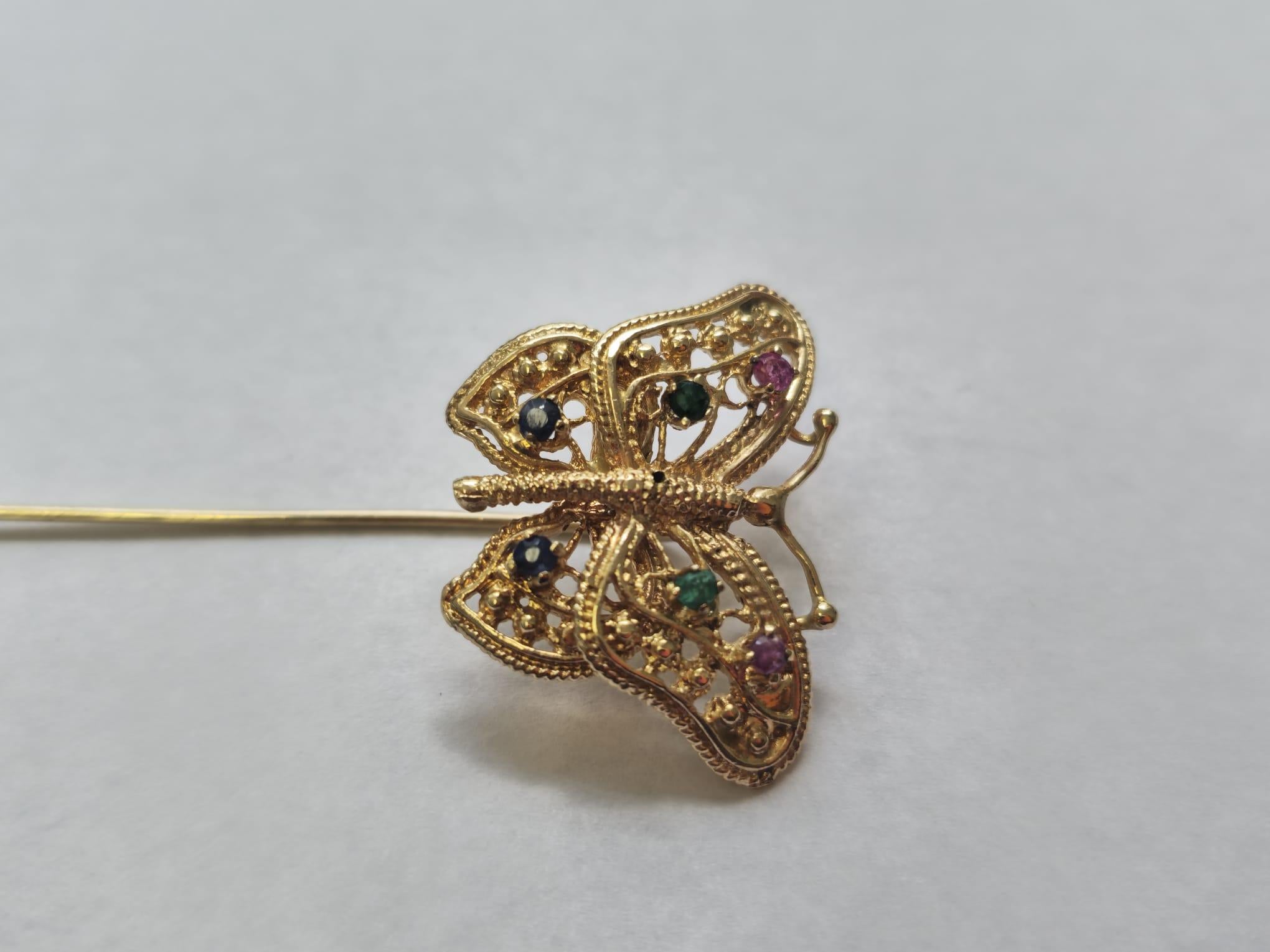 This multigemstone pin is crafted from 18k gold and weighs 4.2 grams, showcasing vibrant emerald, ruby, and sapphire gemstones totaling 0.25 carats. The combination of these colorful gemstones adds a striking touch to this elegant pin, making it a