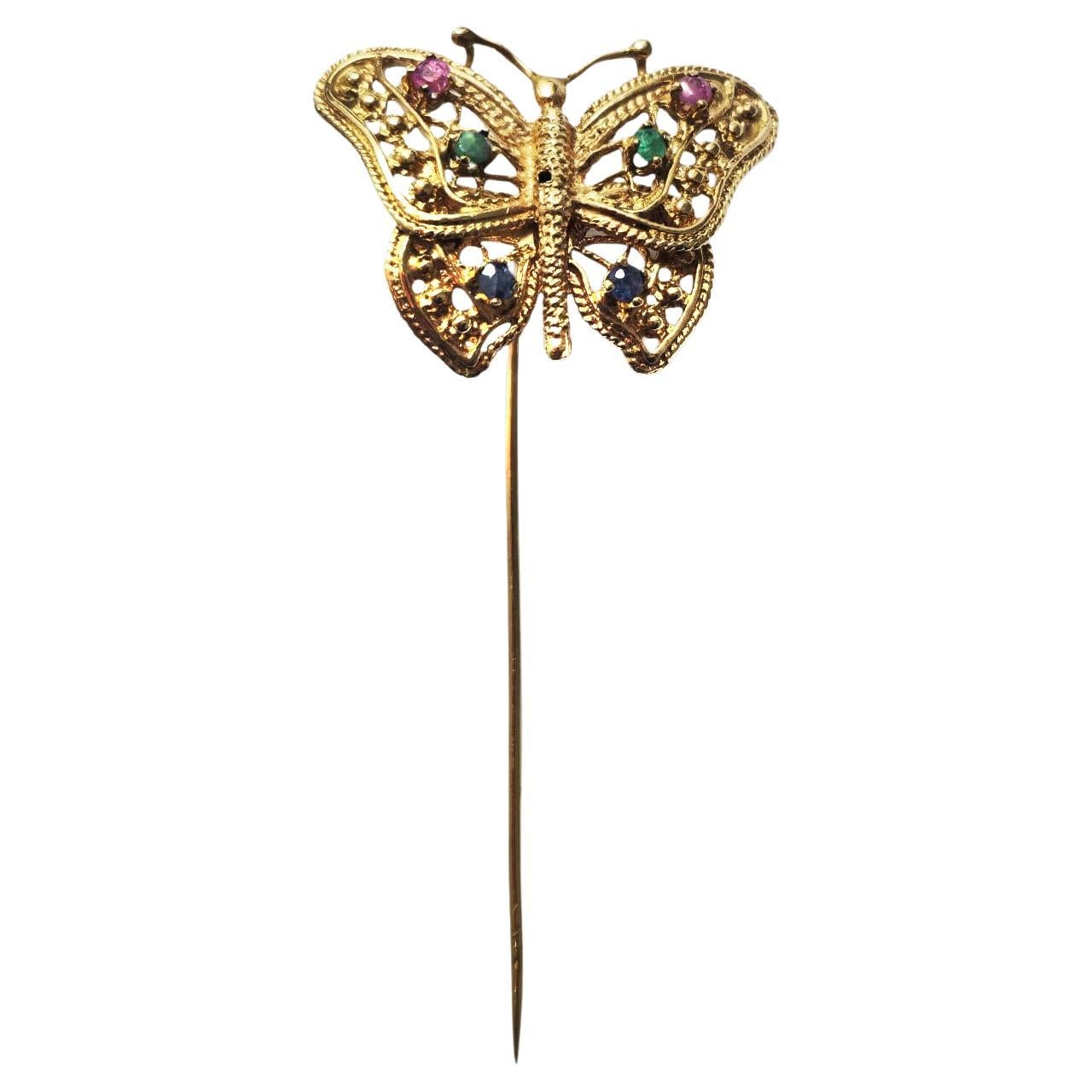 Questa spilla con più pietre è realizzata in oro 18 carati e pesa 4,2 grammi, con pietre vibranti di smeraldo, rubino e zaffiro per un totale di 0,25 carati. La combinazione di queste gemme colorate aggiunge un tocco sorprendente a questa elegante