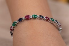 Bracciale tennis con smeraldo, rubino e zaffiro blu e diamanti in oro bianco 18 carati