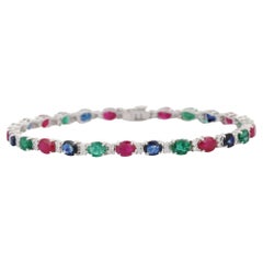 Bracciale tennis con smeraldo, rubino e zaffiro blu e diamanti in oro bianco 18 carati