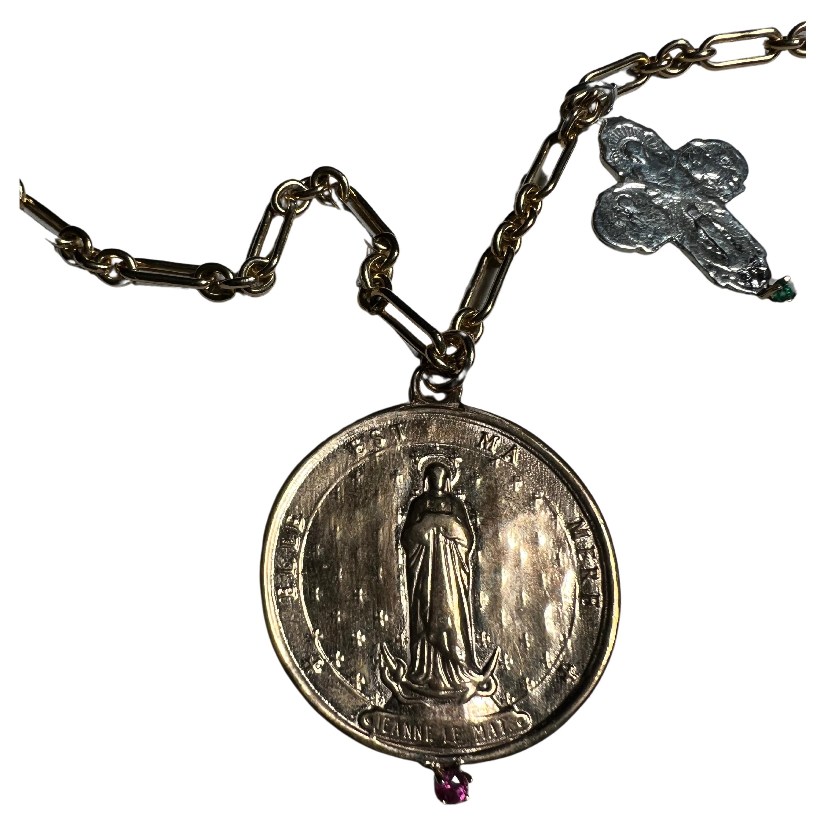 Cruz de plata engastada con esmeralda y medalla con Jeanne Le Mat sosteniendo un rubí en un collar largo de cadena llena de oro del diseñador J Dauphin

Pieza exclusiva con una Moneda de Bronce Redonda con Santa Juana la Mat francesa sosteniendo un