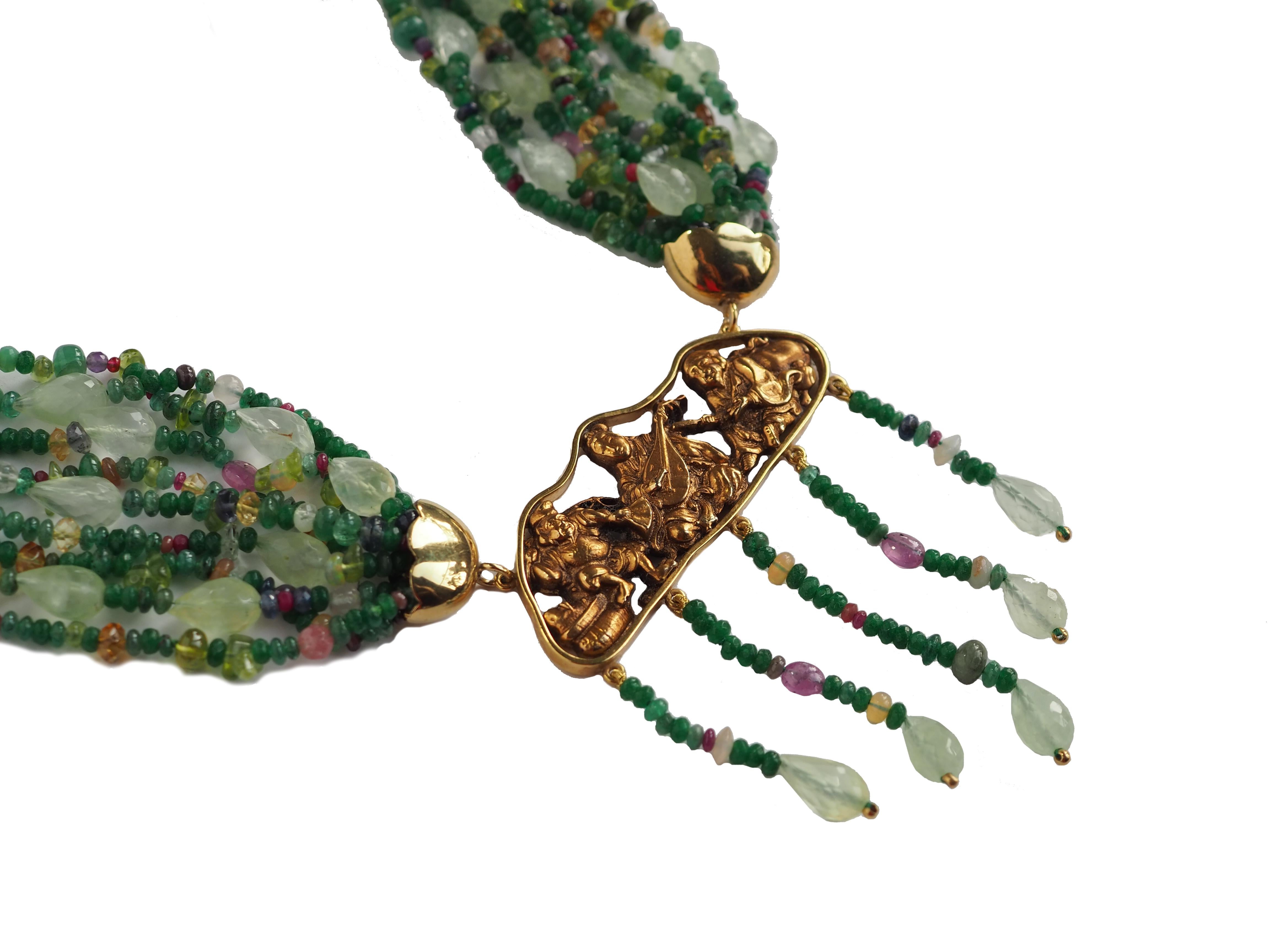 Emerald linked necklace with other stone like ruby and tourmaline,  gold 18 kt 15,80, central part is an antique Japanese gilt metal piece depicting three of the seven 'lucky' gods in Japanese mythology. . Length is adjustable minimum 46cm.
All