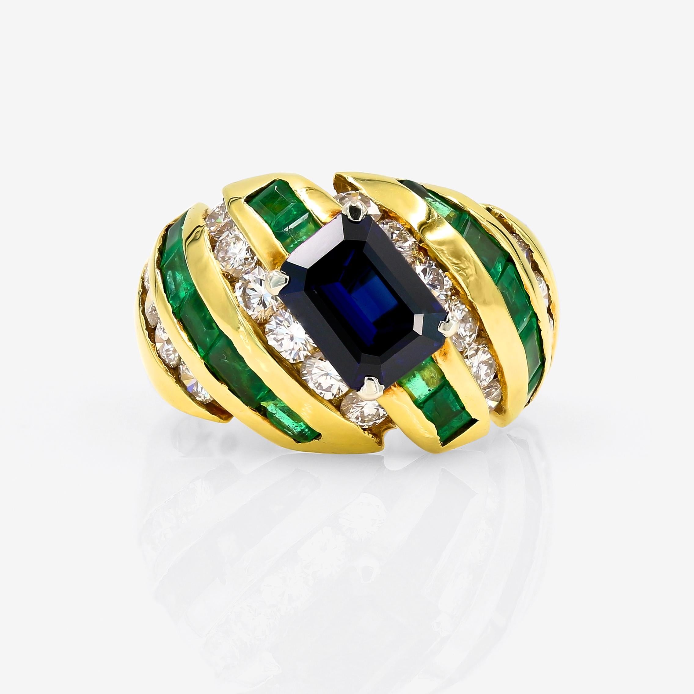 An emerald cut blue sapphire = 1.74cts. is the focal point of this vibrant ring. Set in 18kt. yellow gold, the ring also has 20 round diamonds=1.30cts. t.w, and 14 baguette cut emeralds=1.62cts. t.w. The round diamonds are G-H in color and VS in