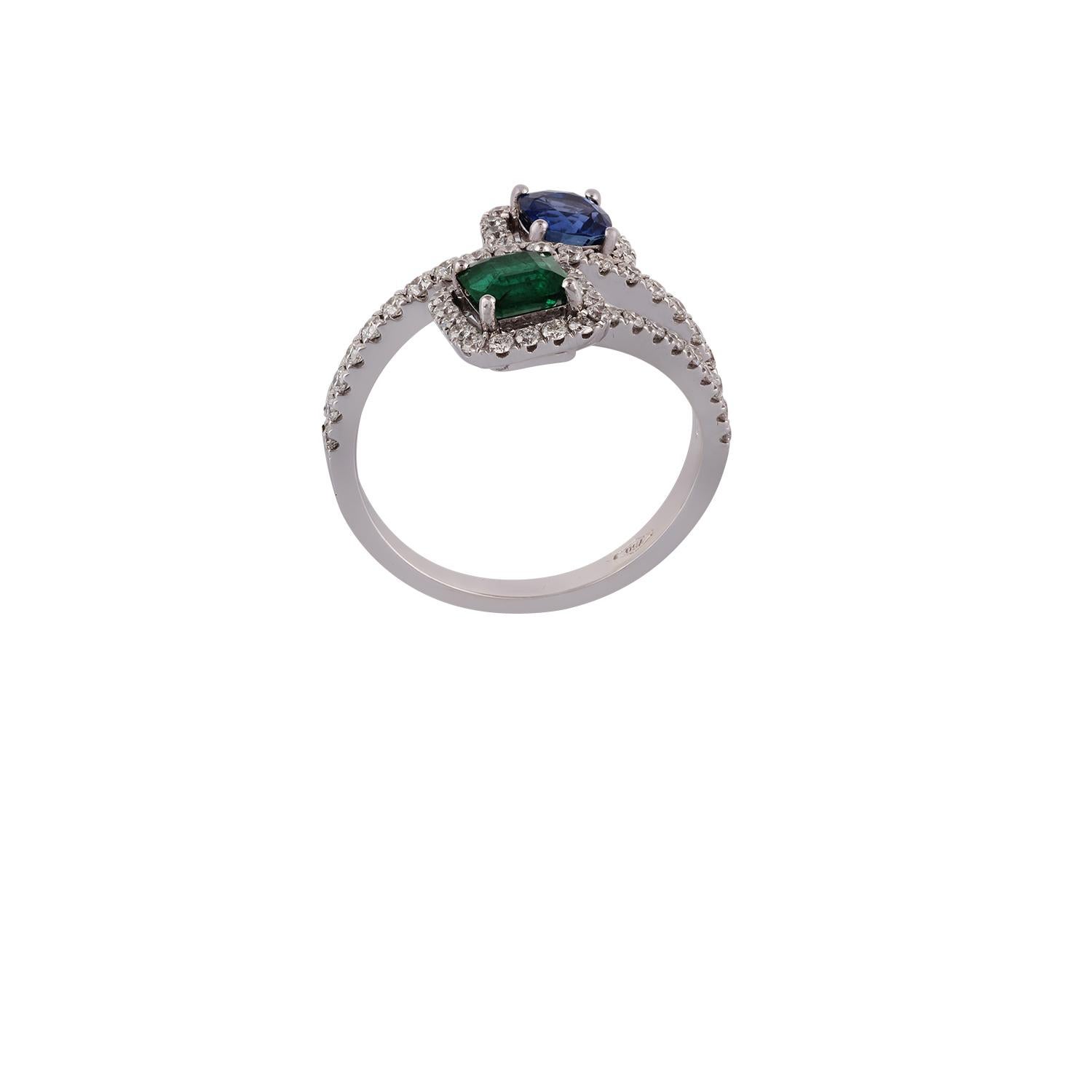 This is an elegant ring studded in 18K white gold features emerald, sapphires & diamonds, the combined weight of emerald & sapphire is 1.02 carats, the ring contains a cluster of diamonds around emerald & sapphire some diamonds are on the shank also