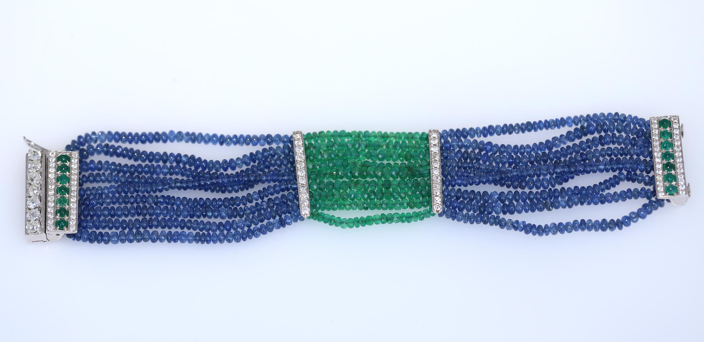 Armband mit Smaragd, Saphir und Diamanten. Entstanden in den 1970er Jahren.
Ein mehrreihiges Armband mit Saphiren und Smaragden. Feine Smaragde mit grünen Facetten. Saphir-Perlen. Eine Reihe von feinen Rundschliff-Diamanten und Cabochon-Smaragden im