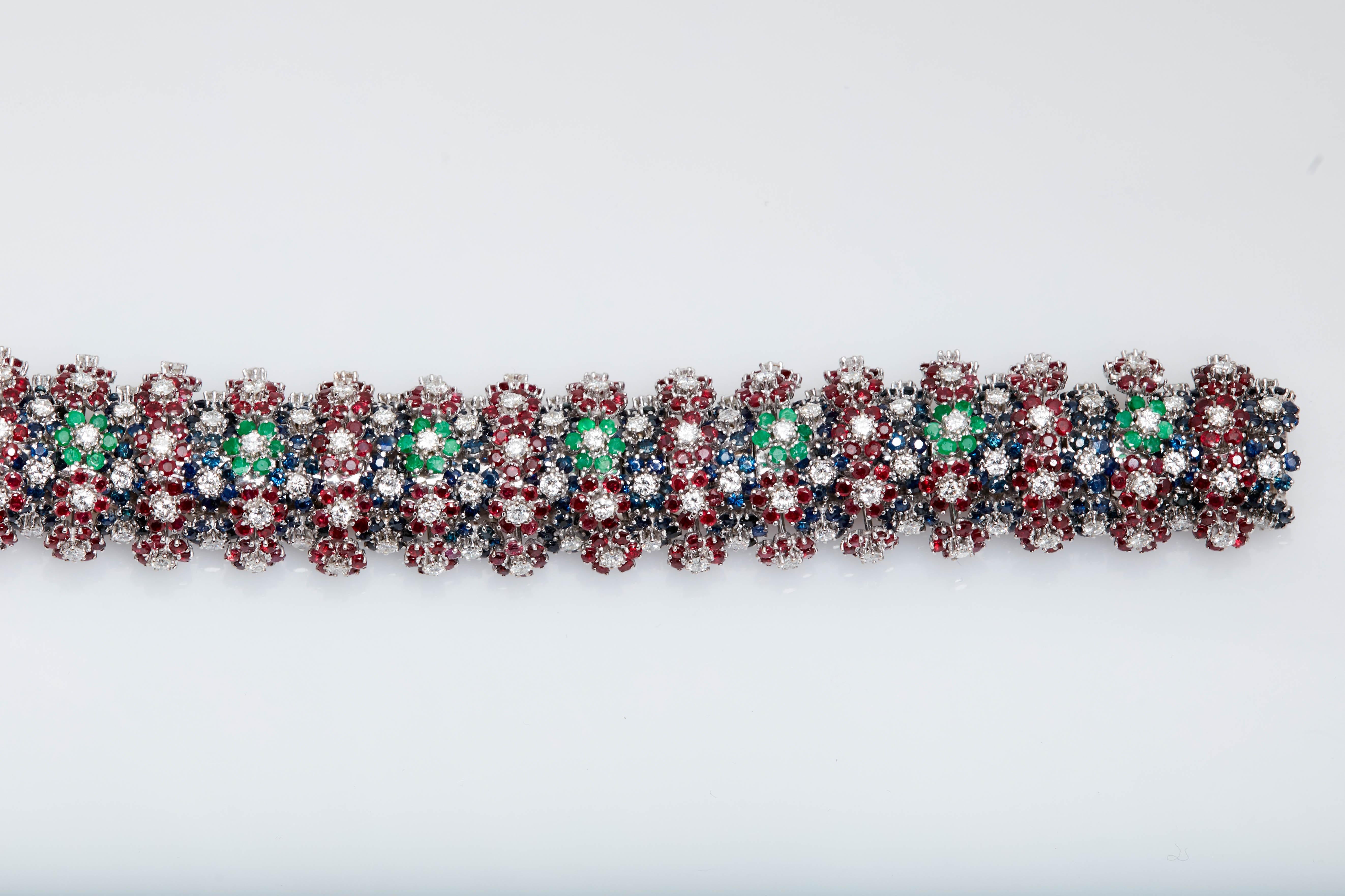 A colorful bracelet with round cut emeralds, rubies, sapphires, and diamonds, mounted on 18kt white gold. Signed by Sanz, an esteemed Spanish jeweler. Made in Spain, circa 1970s. 