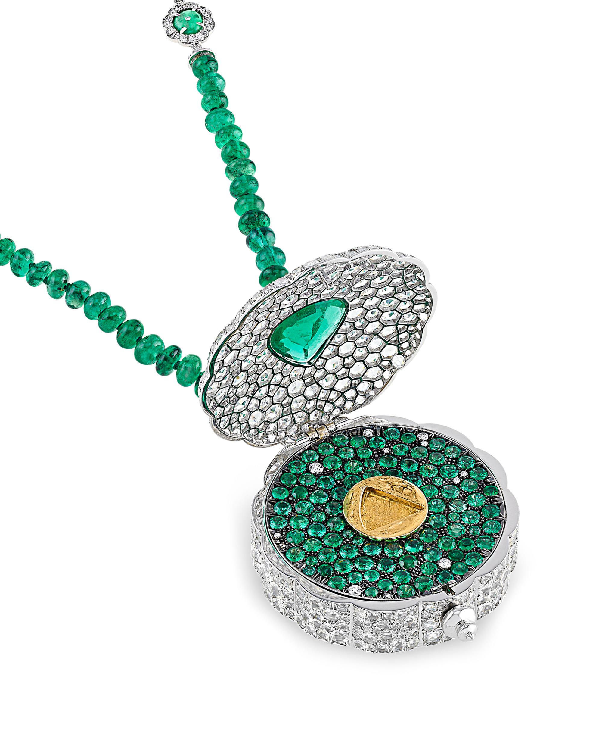 This extraordinary 18K white gold emerald and diamond necklace and ring set exudes an intriguing charm. The ring's fan shape provides a clue to a surprise within the pendant; the pendant contains a secret compartment that can only be accessed with