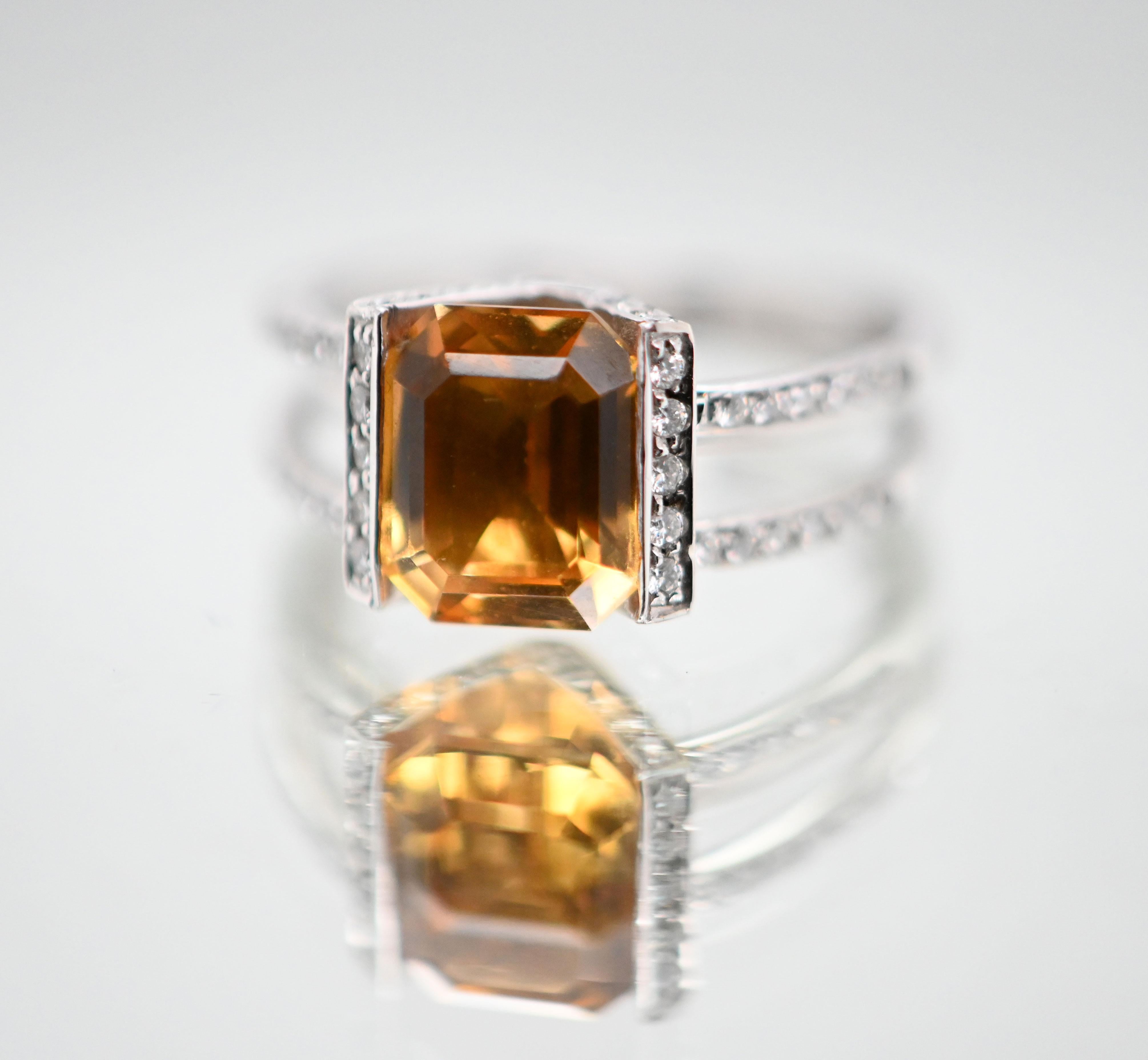 Découvrez cette superbe bague en or blanc 18 carats, ornée d'une citrine de forme émeraude entourée de diamants étincelants. Avec son design délicat et ses finitions soignées, cette bague incarne l'élégance et la sophistication.

Le centre de cette