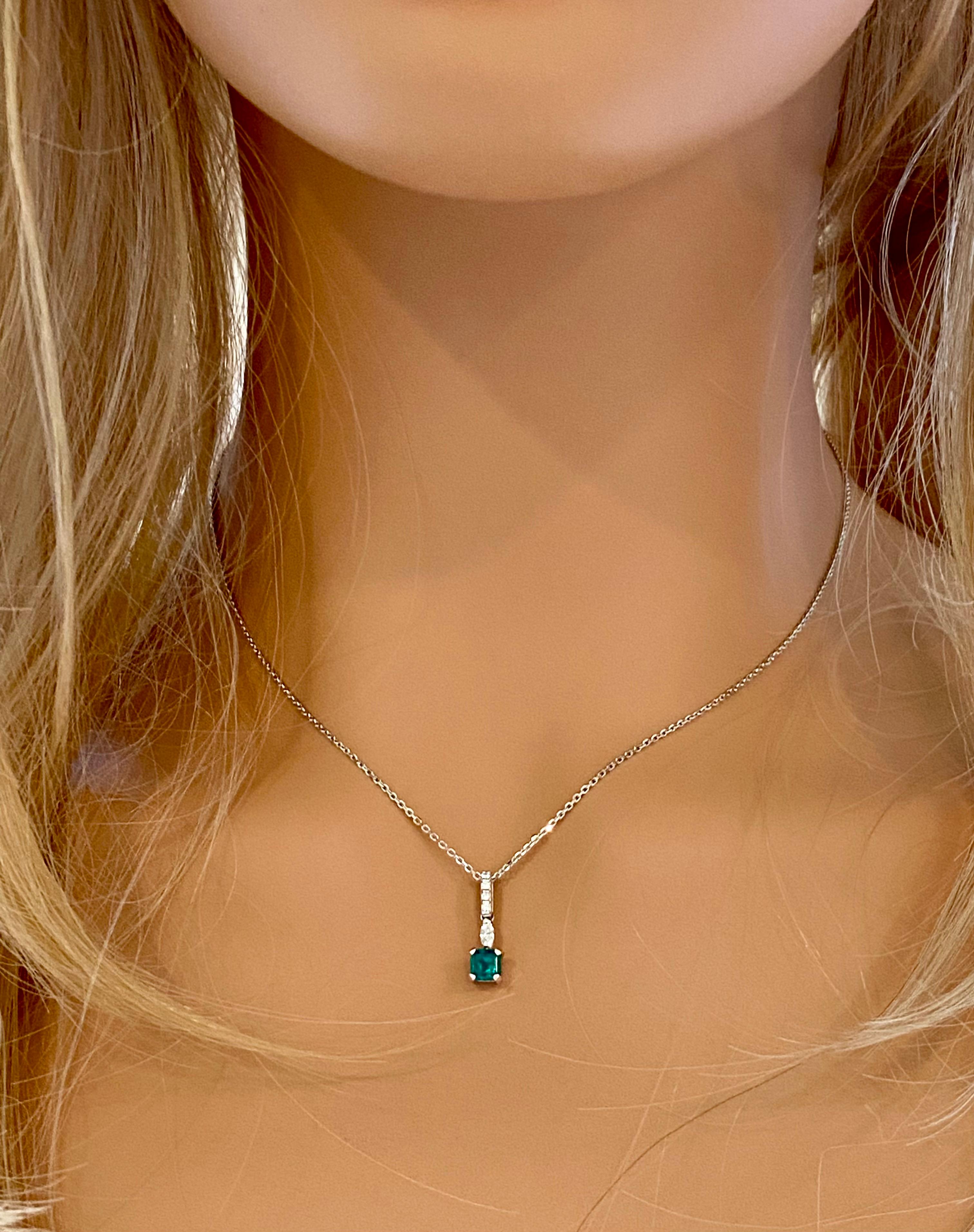 14 karats white gold necklace pendant with emerald-shaped emerald
Necklace measuring 18 inches long
Colombia emerald-cut emerald  weighing 0.90 carats
One marquise diamond weighing 0.10 carats
Diamond bail weighing 0.09 carats
Emerald color hue is