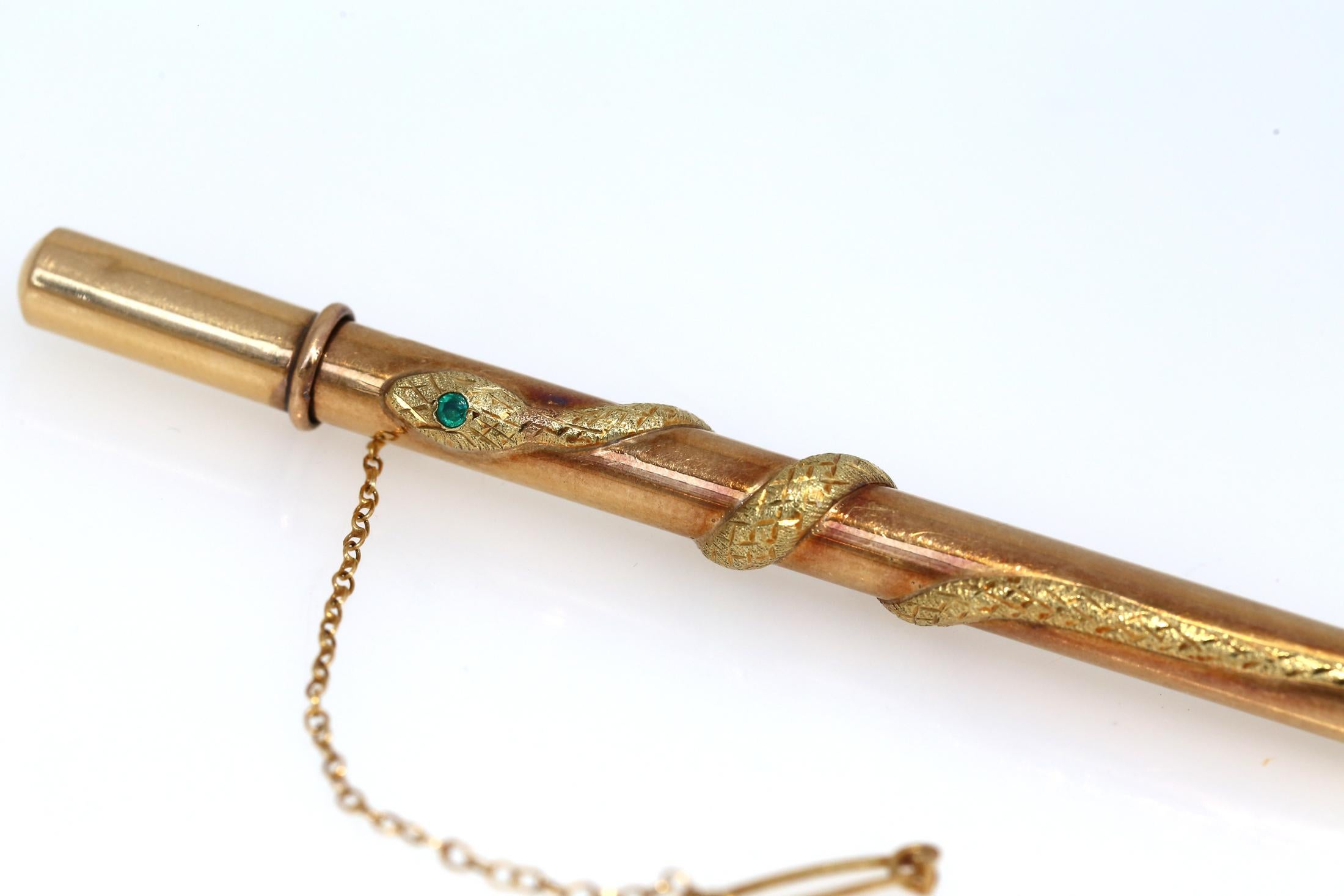 Fine antique example of a Gold pencil case, that was carried on the dress for high society members. Very delicate item, depicting a snake all around the pencil with a fine tiny Emerald. It could be a doctor's item. Has a pin on a chain for security,