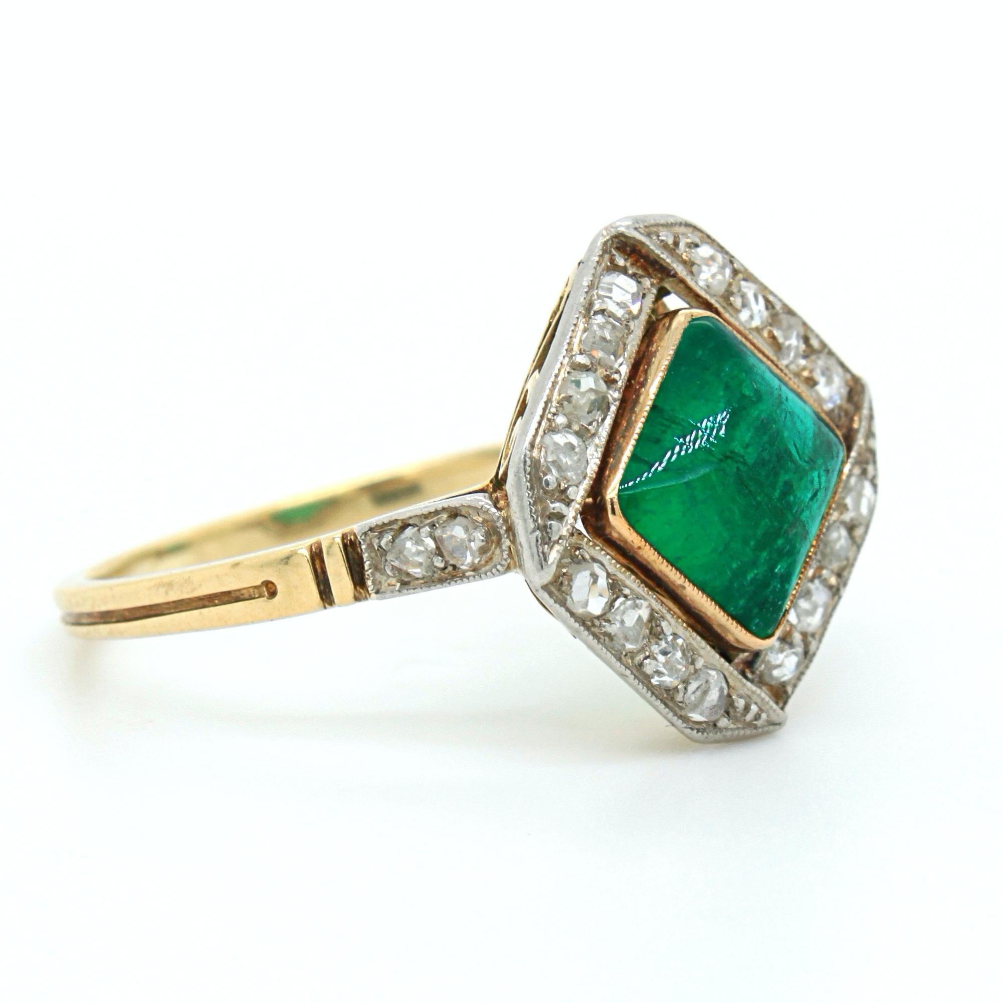 An emerald sugarloaf and diamond ring, Edwardian, ca. 1900s. The emerald is of Columbian origin and has a very attractive square sugarloaf shape, weighing approximately 2 carats. It is bezel set and affixed from the bottom, which allows the centre