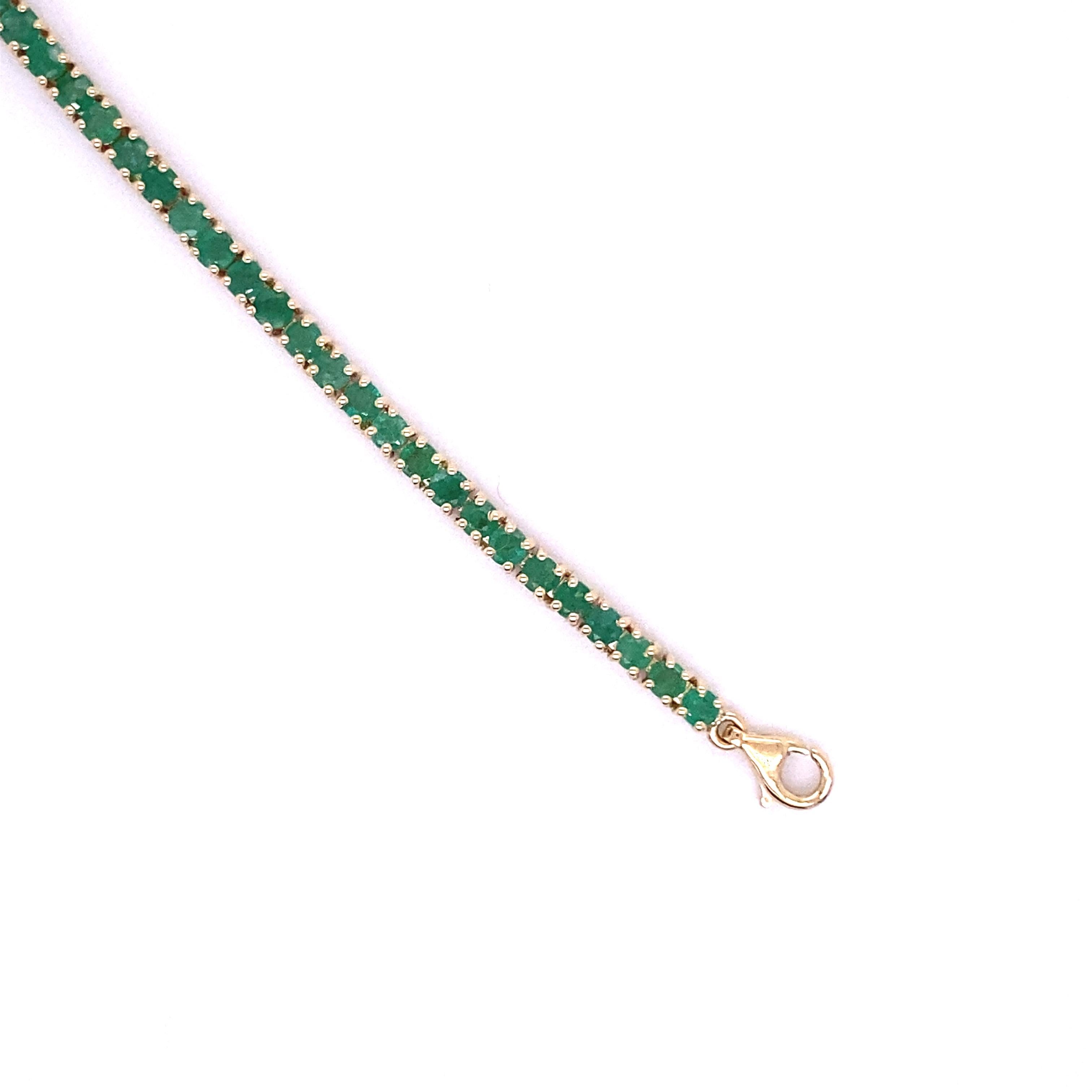 Add a bold pop of color to your look with this tennis bracelet. Its unique design features a row of emeralds set in a 14K yellow gold setting. The round emeralds prong set along a 14K yellow gold chain. This bracelet is a must-have for a woman who
