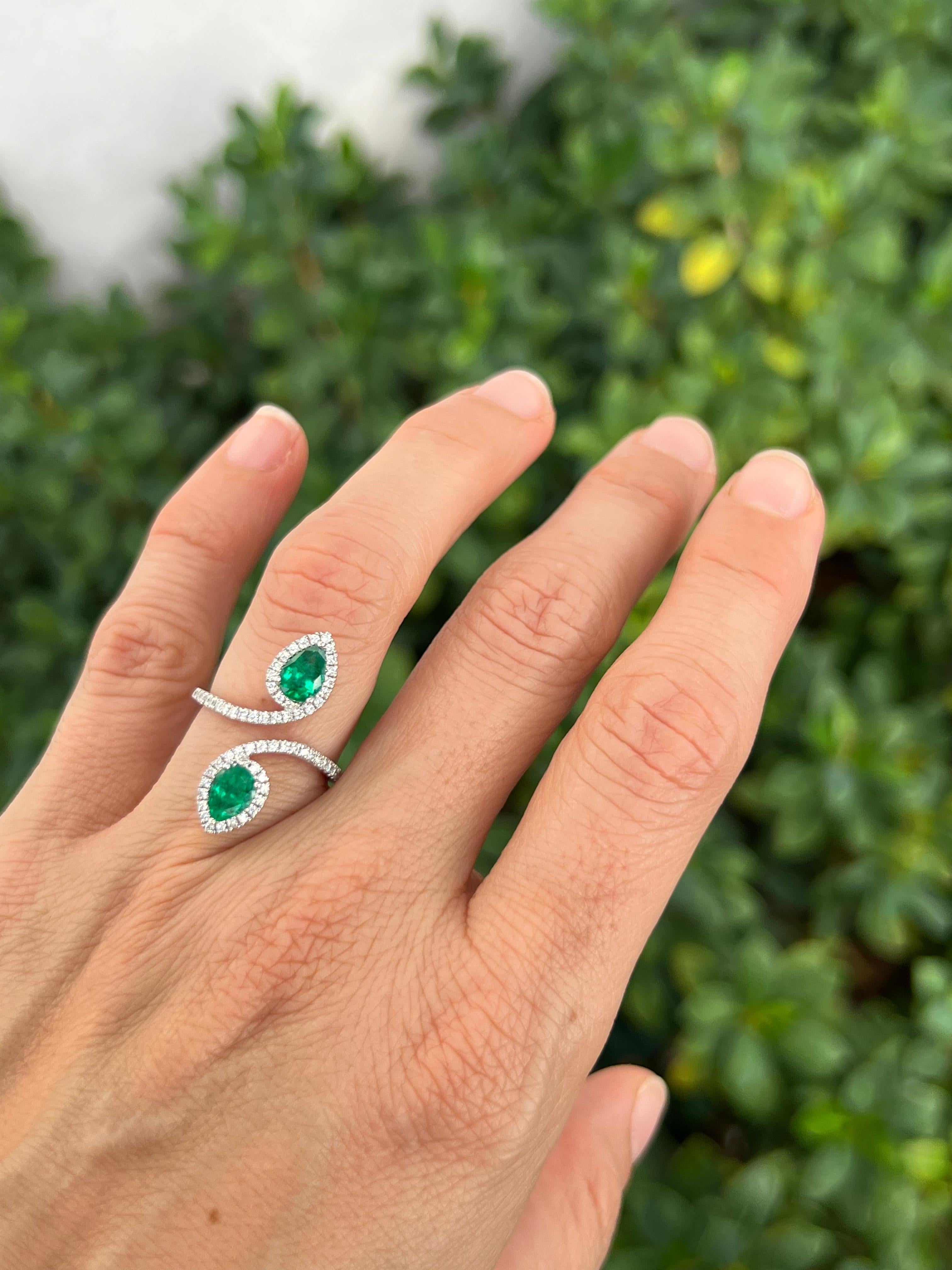 Get noticed with this 18K white gold, two stone emerald ring with diamond accents. Featuring two bright pear-shape emeralds in an elongated moi et toi style. 

Features
18K tricolor gold
1.10 carat total weight emerald
.38 carat total weight in