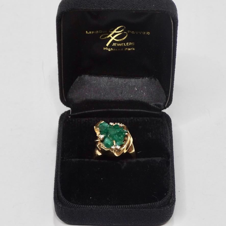 Get your hands on this incredible 1970 uncut emerald ring! 14K yellow gold beautifully contrasts a unique uncut emerald surrounded by 6 round diamonds. The rugged cut of this stone really elevates this ring from a beautiful classic piece to an eye