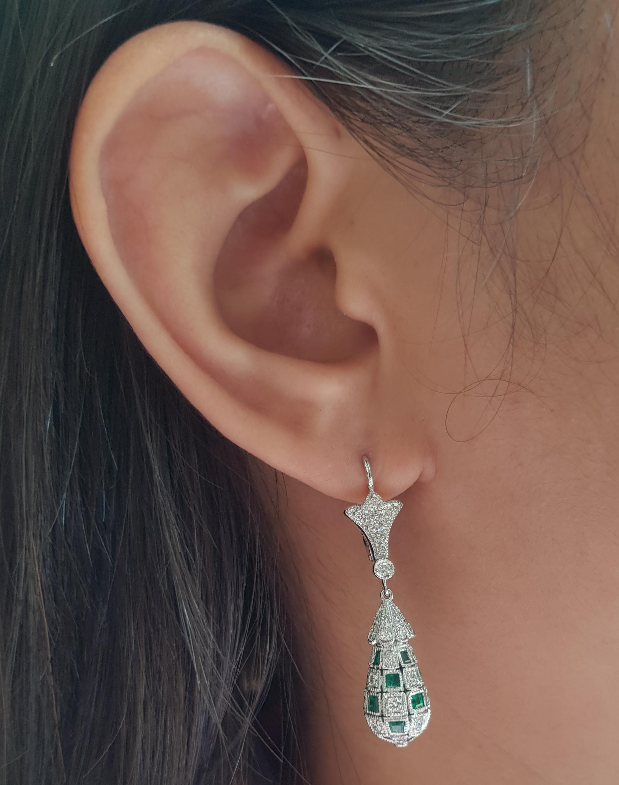 Boucles d'oreilles composées d'une émeraude de 3,52 carats et d'un diamant de 1,28 carat, serties dans une monture en or blanc 18 carats

Largeur :  0.9 cm 
Longueur : 3,9 cm
Poids total : 9,57 grammes

