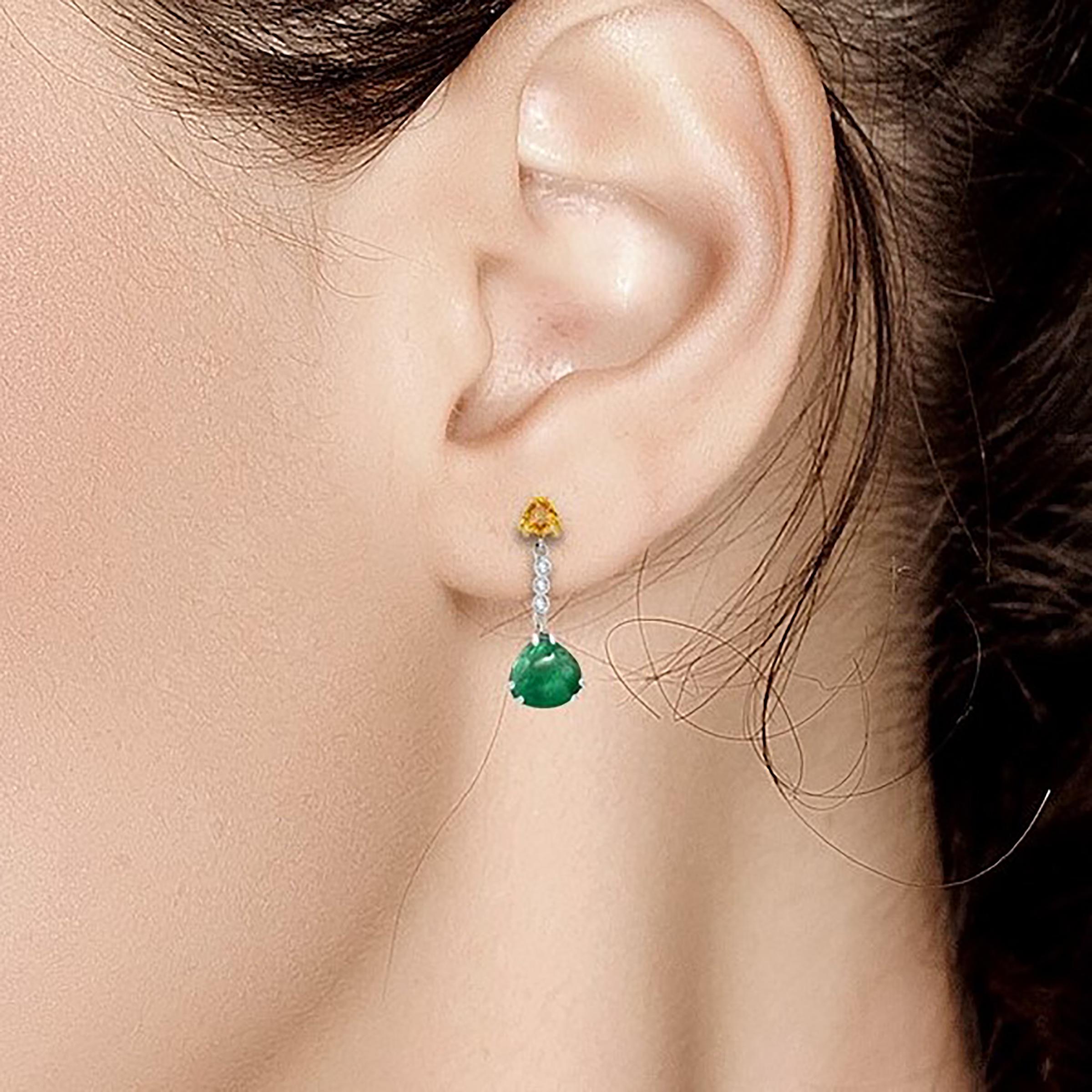 Fourteen karats white and yellow gold drop earrings 
Two triangles shaped cabochon emerald weighing 4.81 carat 
Yellow sapphire weighing 0.85 carat 
Diamonds weighing 0.15 carat
Earrings measuring 1