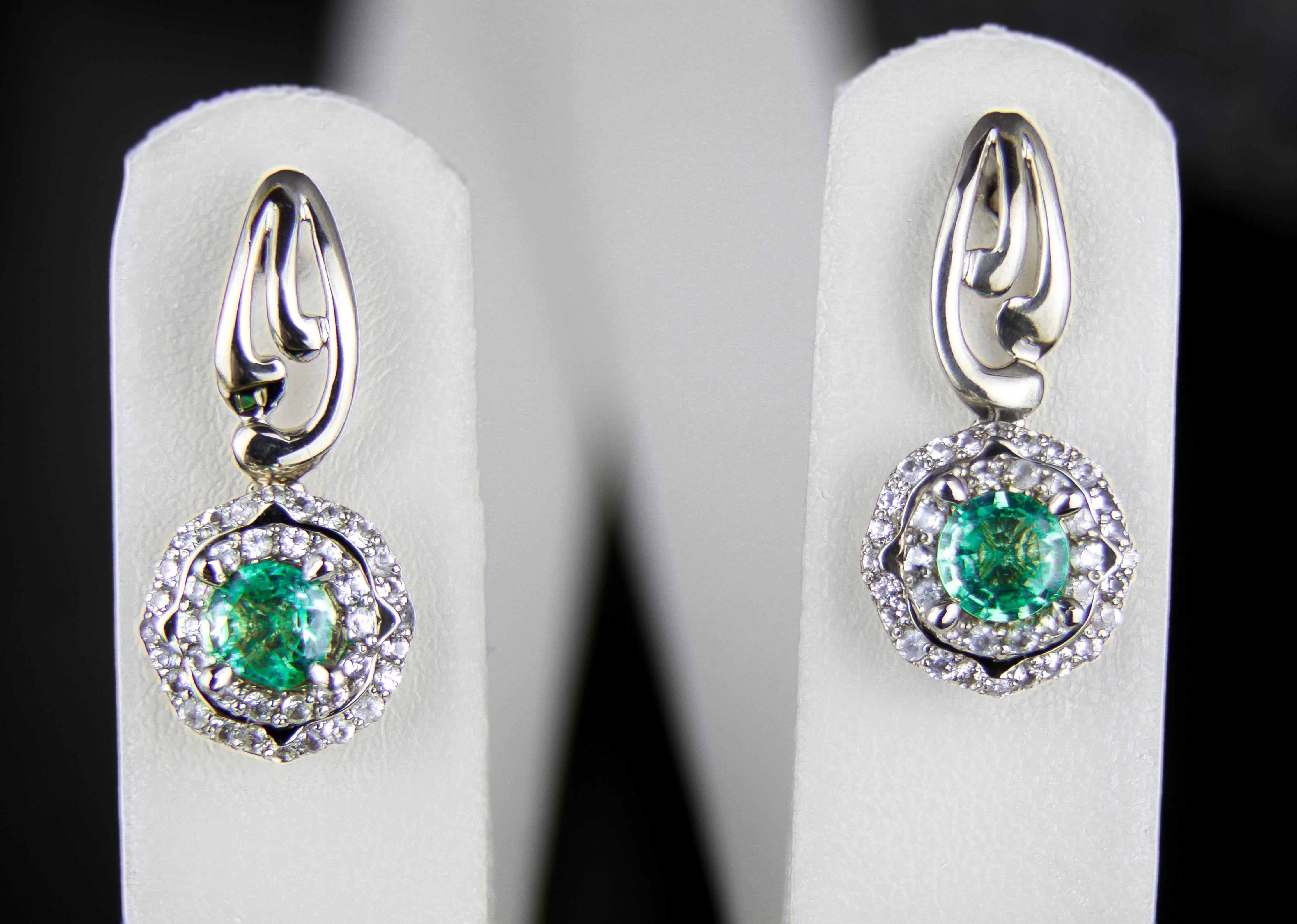 Emeralds 14k gold earrings studs.  

Metal type: Gold
Metal stamp: 14k Gold
Weight: 3.4 gr
Size 11x6.5 mm
Central gemstones:
Natural emeralds
Round cut
Weight: aprox 1 ct
Color: green
Surrounding stones: diamonds, G\VS, round brilliant cut, 0.28 ct