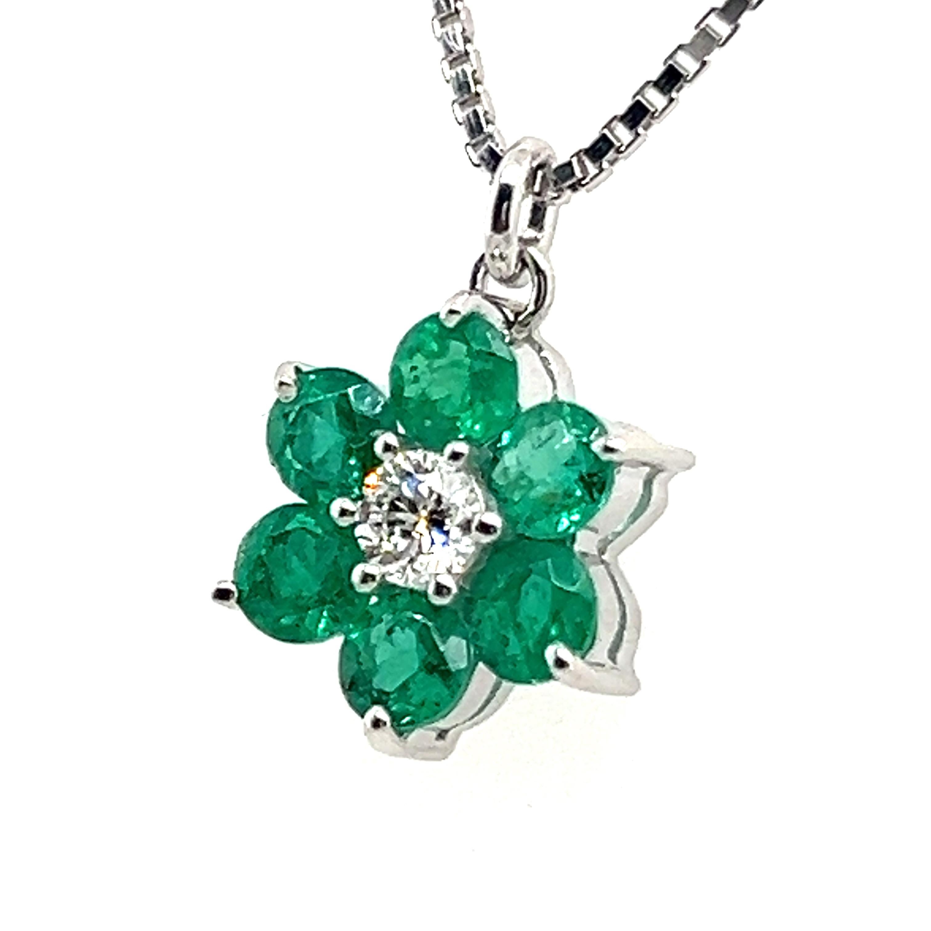 Crafted with gentle attention to detail, this pendant from 18 Karat white gold features a cluster of six emeralds, totaling 0.78 carats, reminiscent of lush green petals. Nestled within the heart of this floral masterpiece is a brilliant-cut