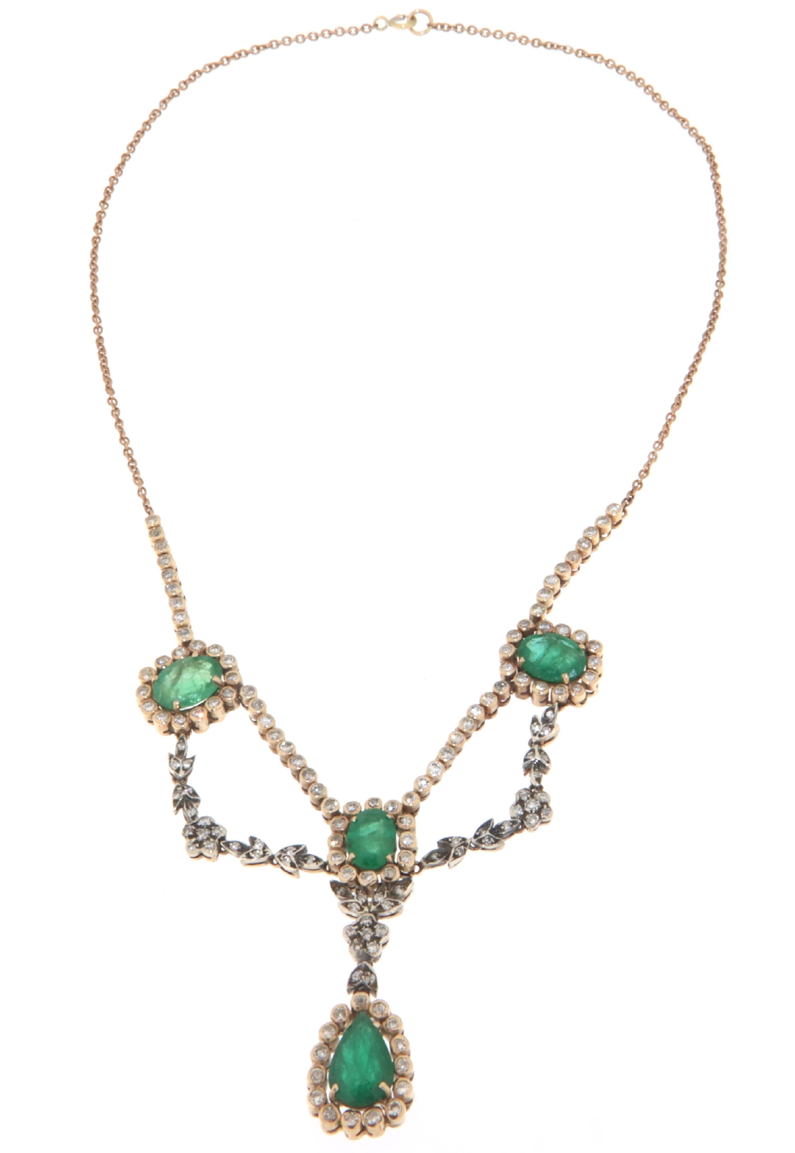 This necklace in 9 karat yellow gold and 800 millesimal silver is an extraordinary example of craftsmanship and elegant design. The central piece of the necklace is adorned with high-quality diamonds and emeralds, creating an impressive visual