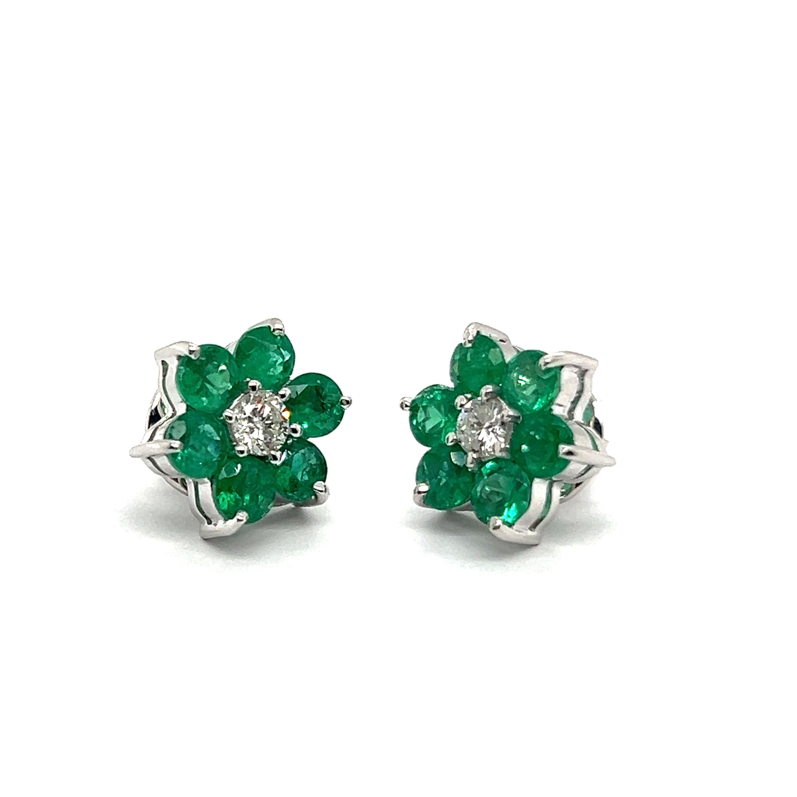 Capture the essence of spring with this stunning emerald and diamond flower stud earrings in 18 Karat white gold.

Resembling petite green daisies each feature six emeralds totaling 1.56 carats. At the center of the blossoms, gleams two diamonds of
