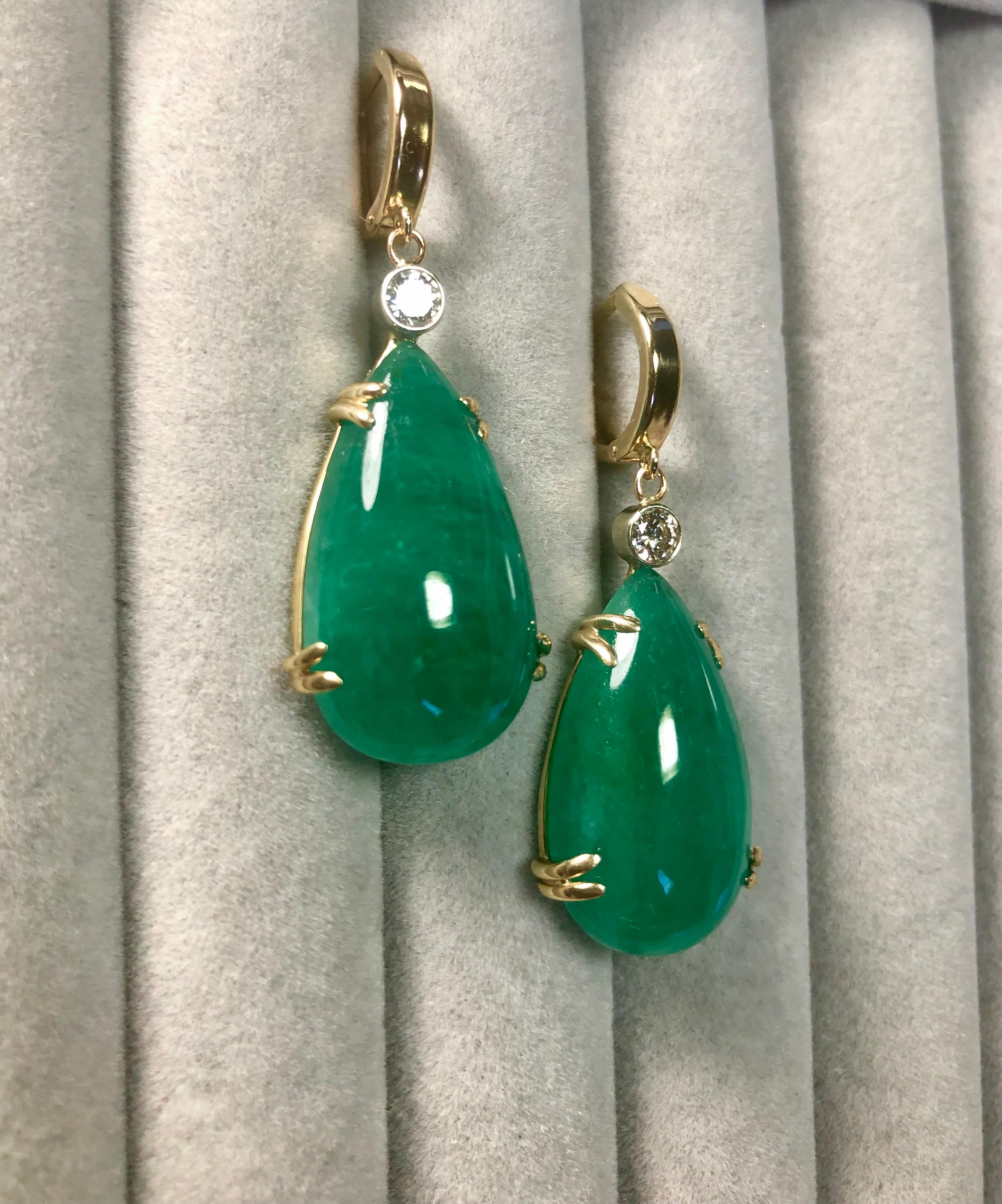 Stunning hanging earrings comprising of two pear cabochon-cut natural emeralds weighing 35.54 carats.  Excellent medium vivid green color. The emeralds are certified by CDTEC stating that they are of Colombian origin with moderate clarity